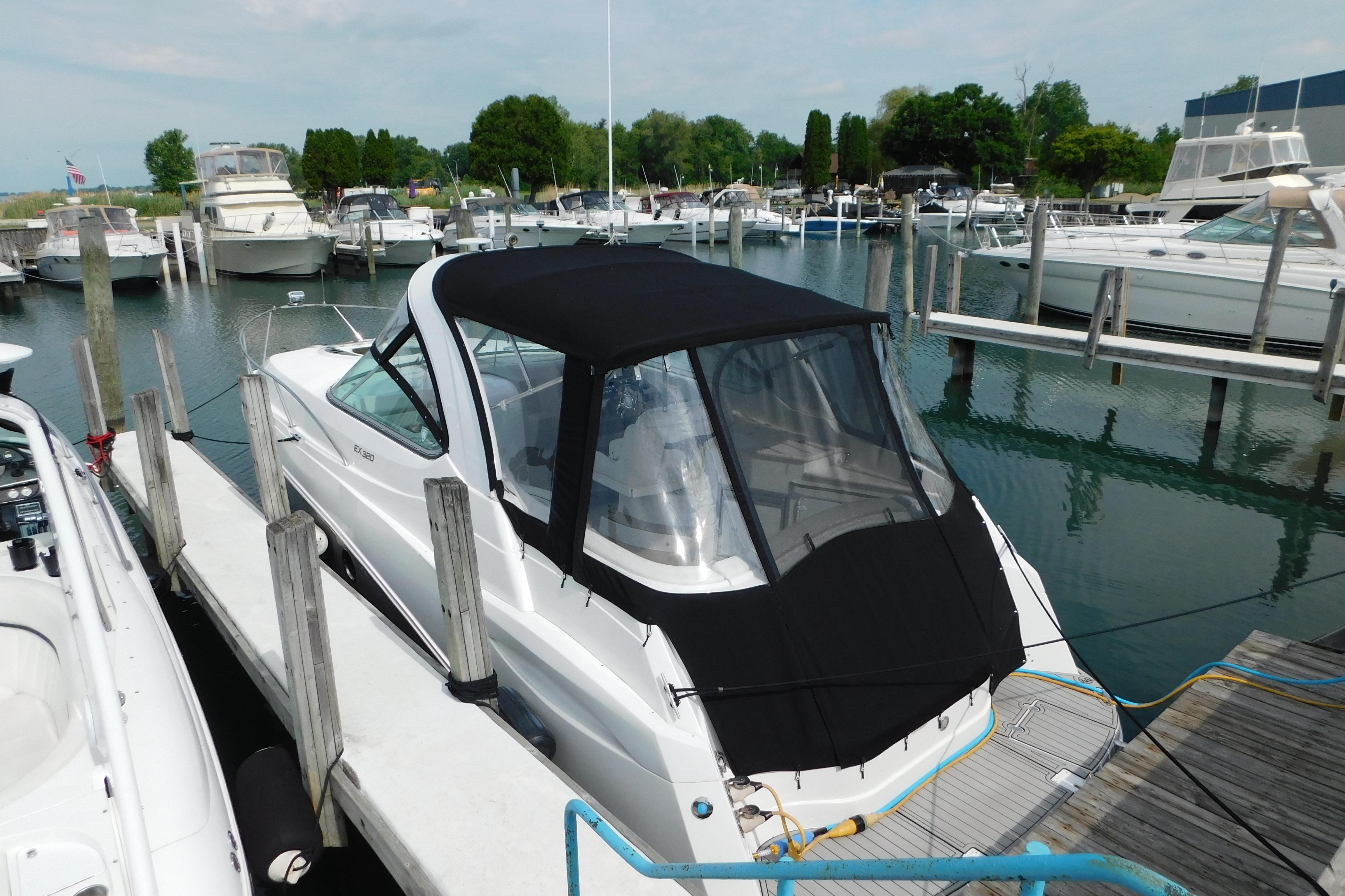2017 Rinker EX 320 boat docked in a marina with other vessels.