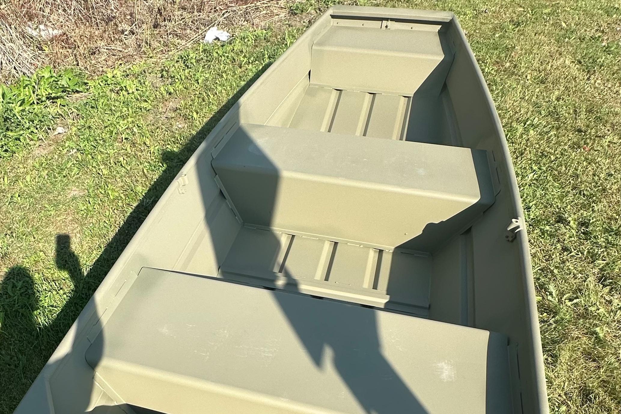 2026 Tracker Grizzly 12 Jon boat on grass, showcasing interior seating and design.