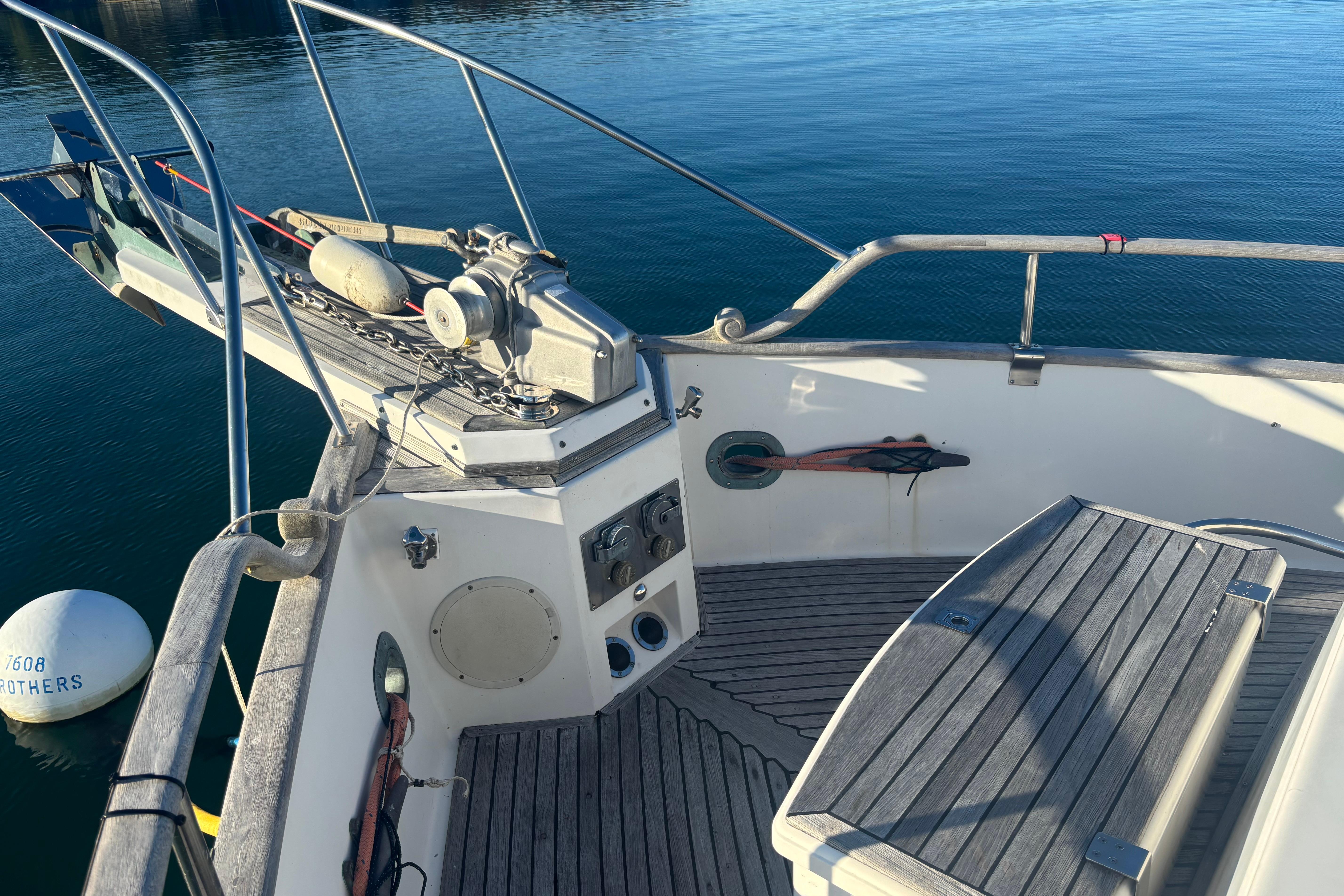 1989 Grand Banks 46 Classic yacht deck with anchor and wooden seating.