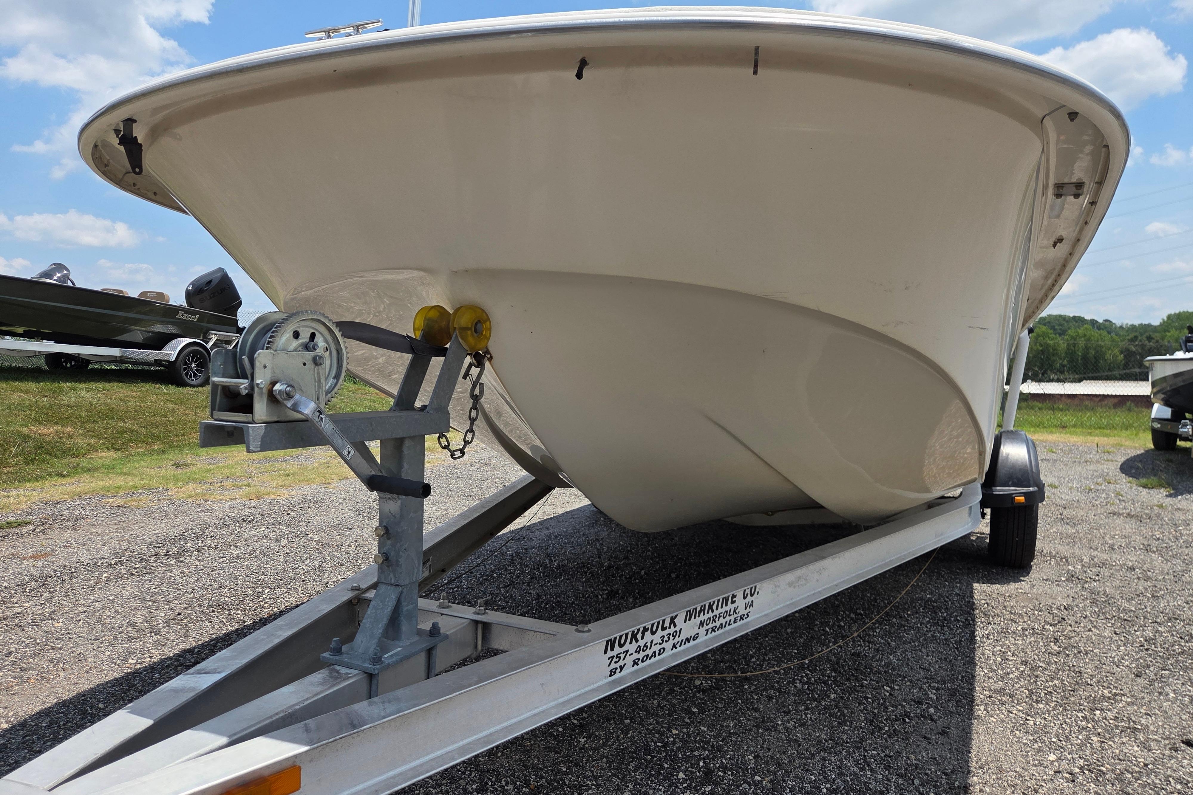 2016 Carolina Skiff 198 DLV boat on trailer, parked outdoors under a blue sky.