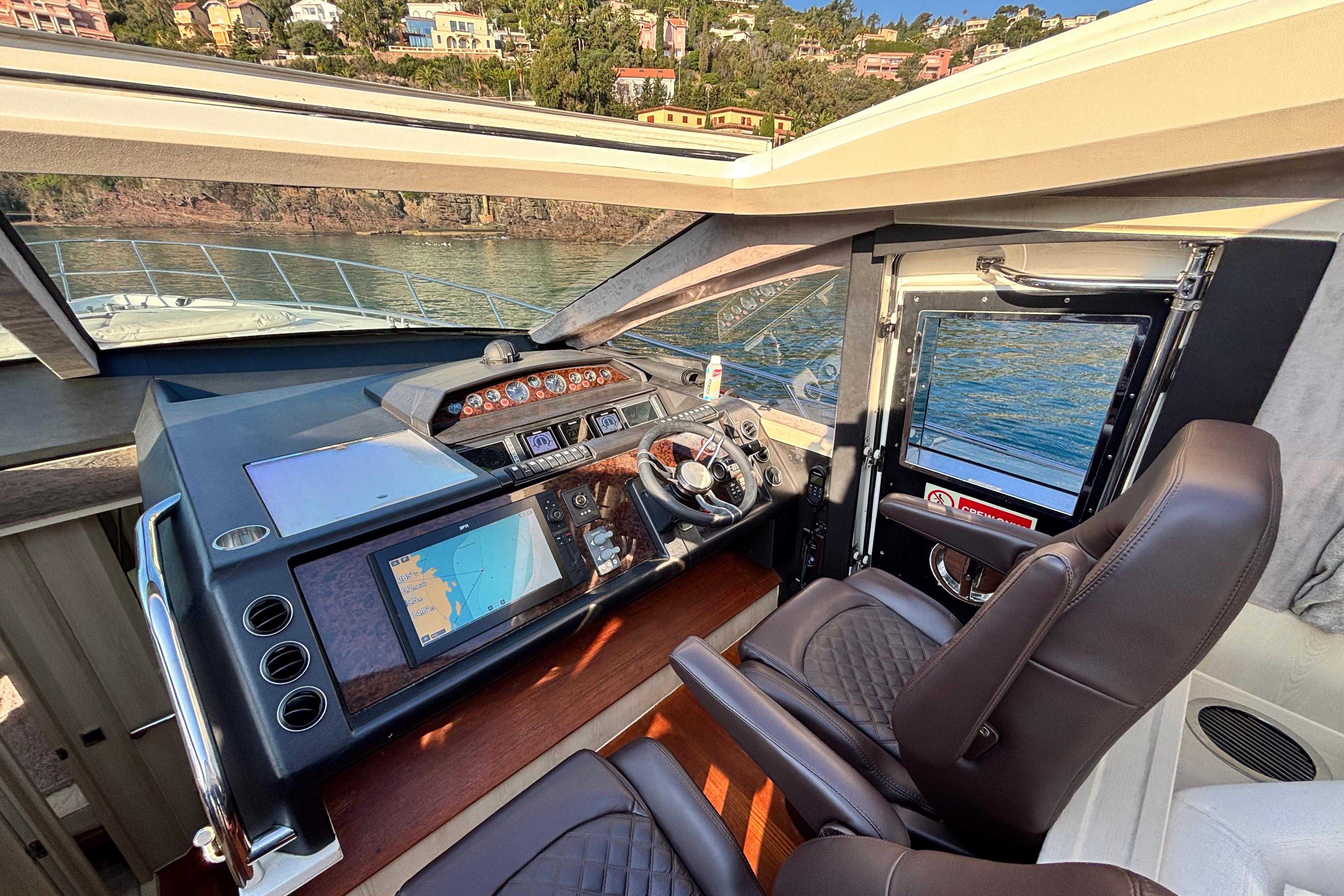 Luxurious 2006 Princess V70 yacht cockpit with modern navigation system and leather seating.