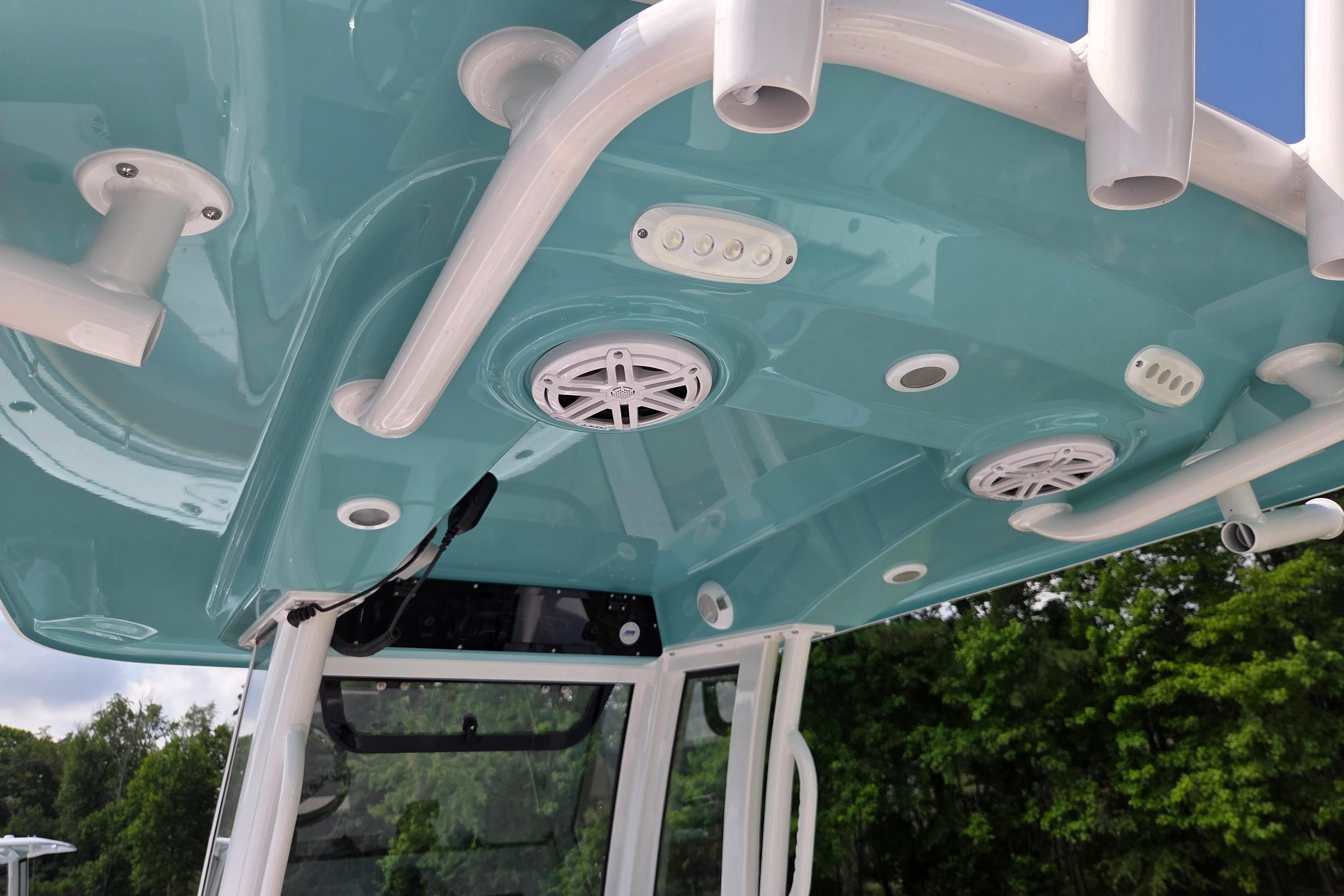 2026 Sportsman Open 232 Center Console boat with teal canopy and integrated speakers.