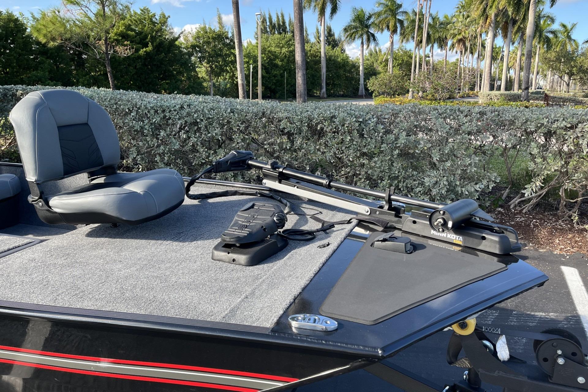 2026 Tracker Bass Tracker Classic XL boat with seating and trolling motor, surrounded by lush greenery.