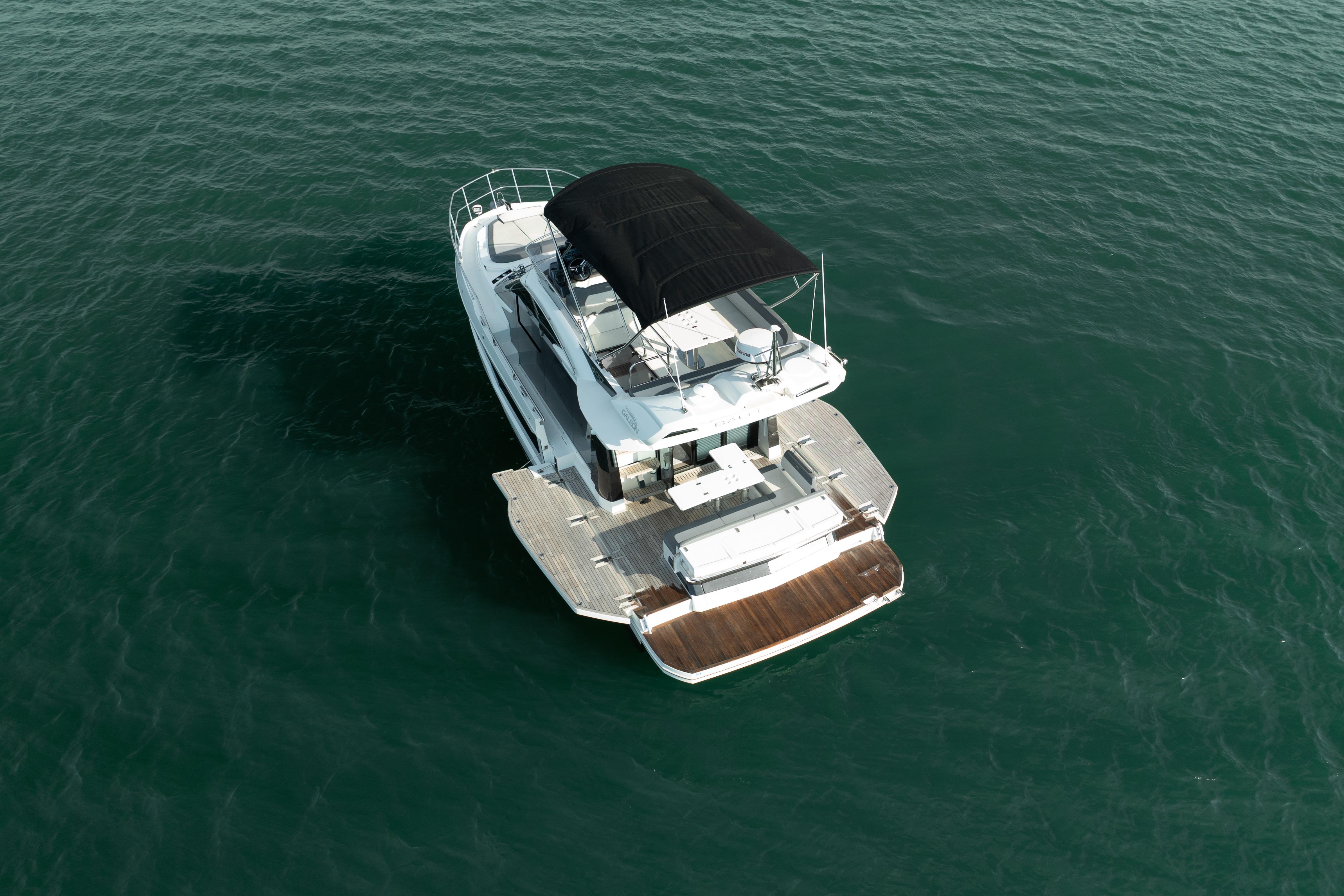 2023 Galeon 400 Fly yacht with black canopy on open water.