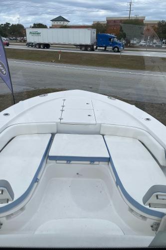2026 Robalo 246 Cayman boat bow view with highway and truck in background.