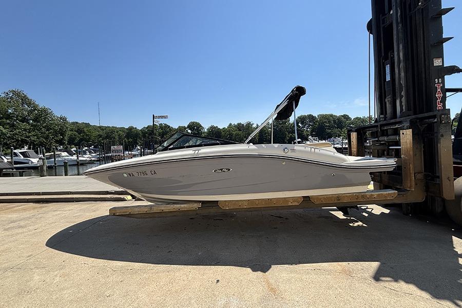 2018 Sea Ray SPX 190 boat on forklift at marina, clear sky background.