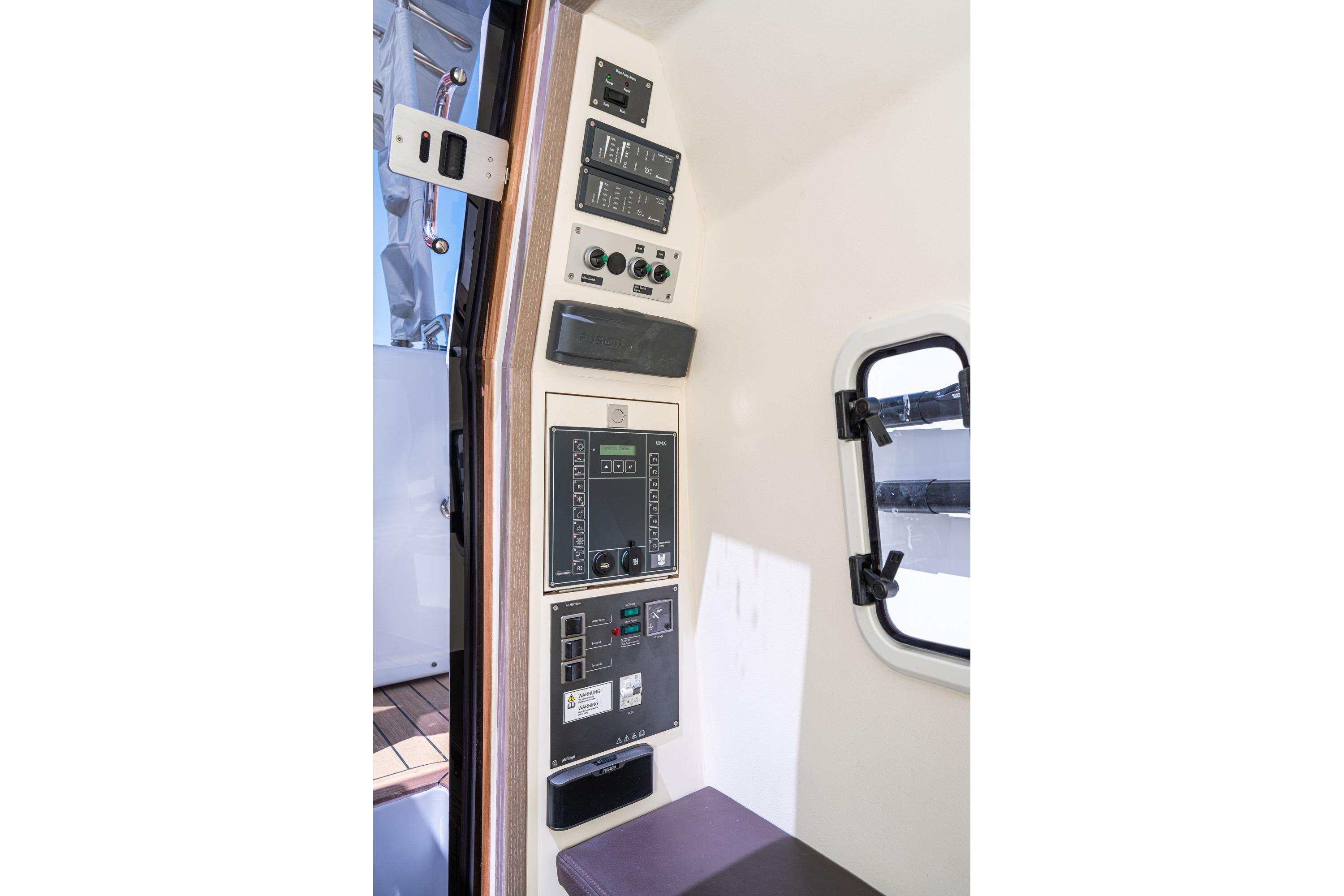Control panel inside 2018 Fjord 36 Xpress boat, featuring various switches and displays.