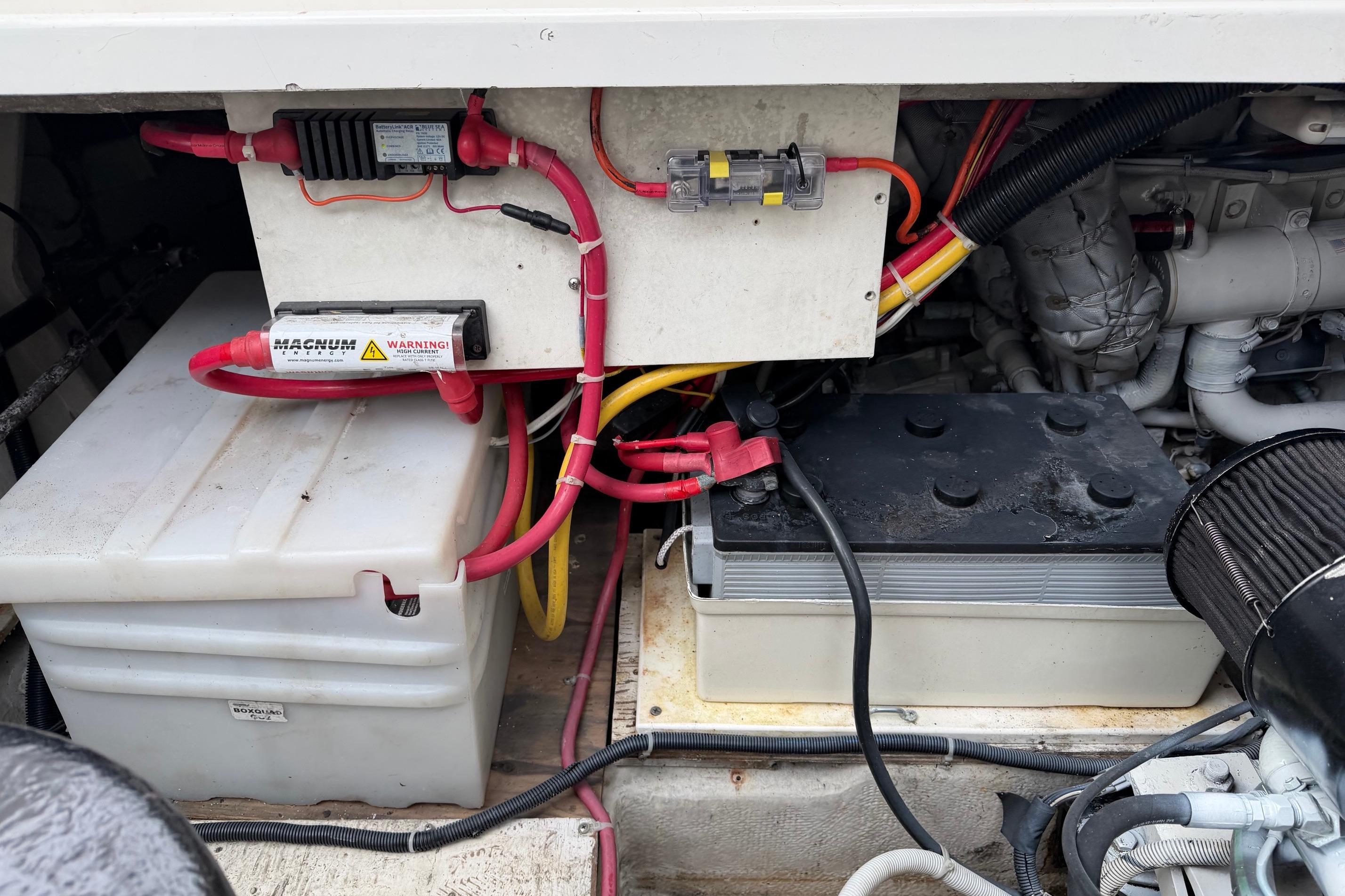 Engine compartment of a 1998 Bayliner 3388 Command Bridge Motoryacht, featuring batteries and wiring.