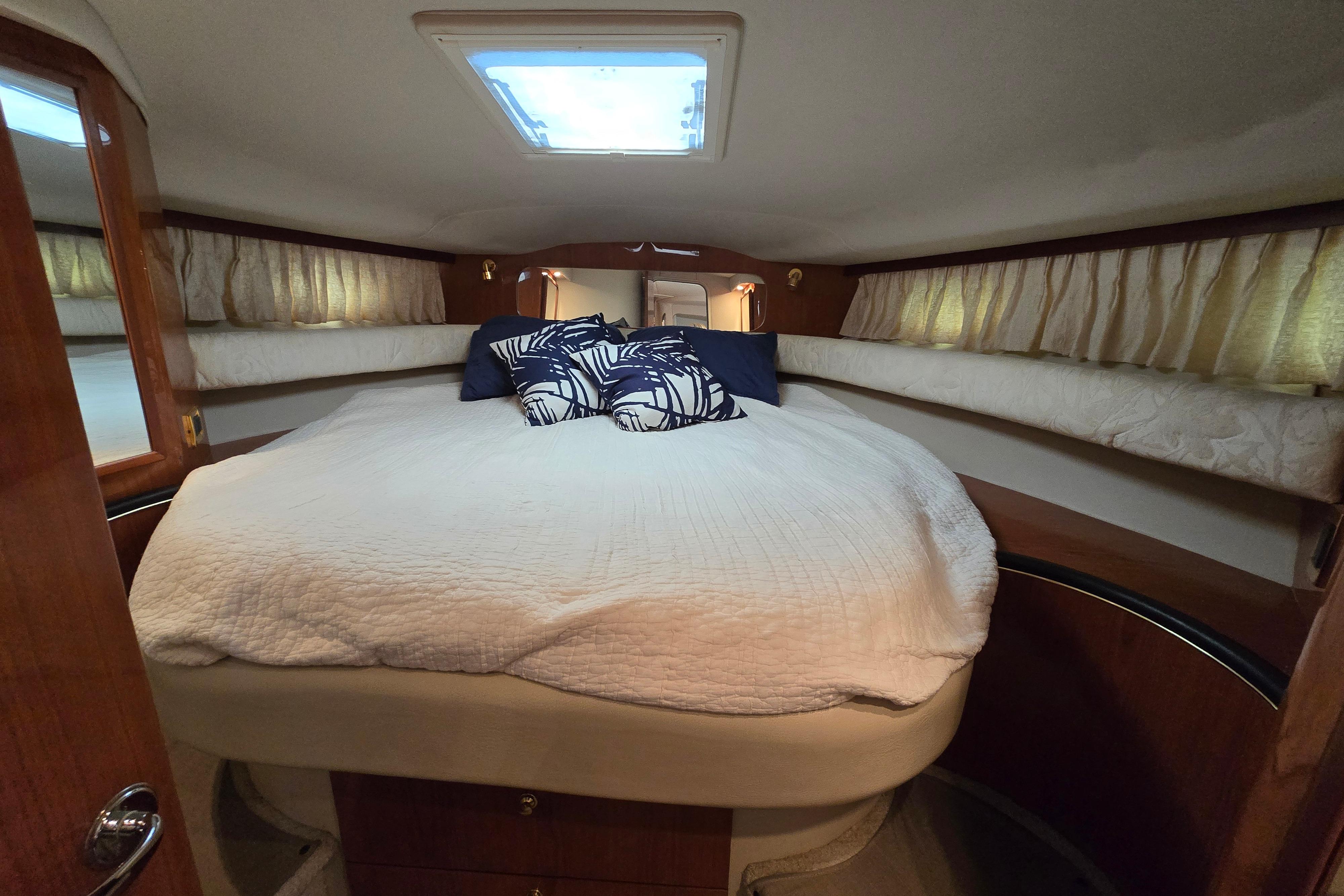 1999 Sea Ray Sundancer 400 cabin with cozy bed, pillows, and natural light.