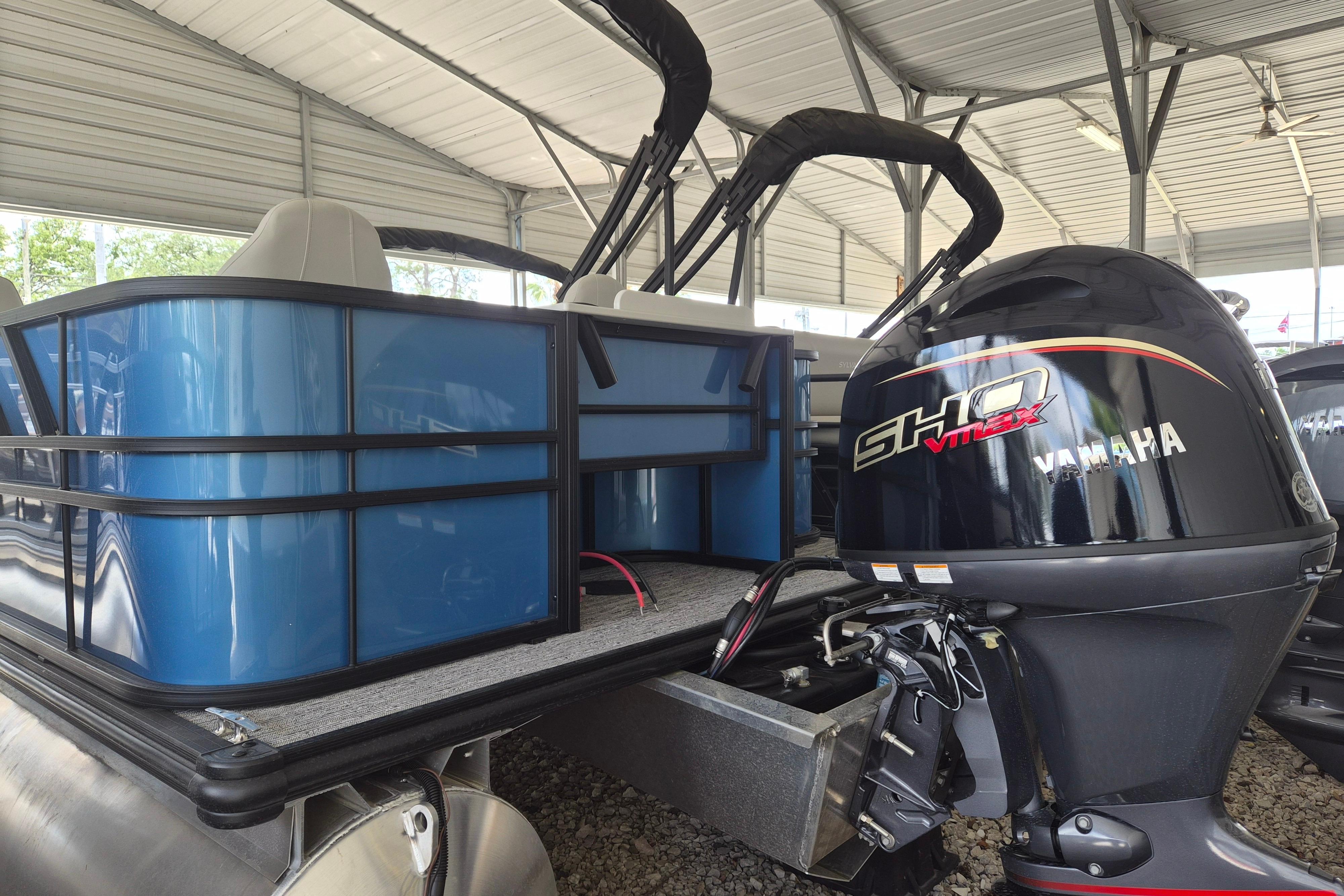 2026 Sylvan Mirage Fish 820 Party Fish pontoon with Yamaha outboard motor in covered storage.