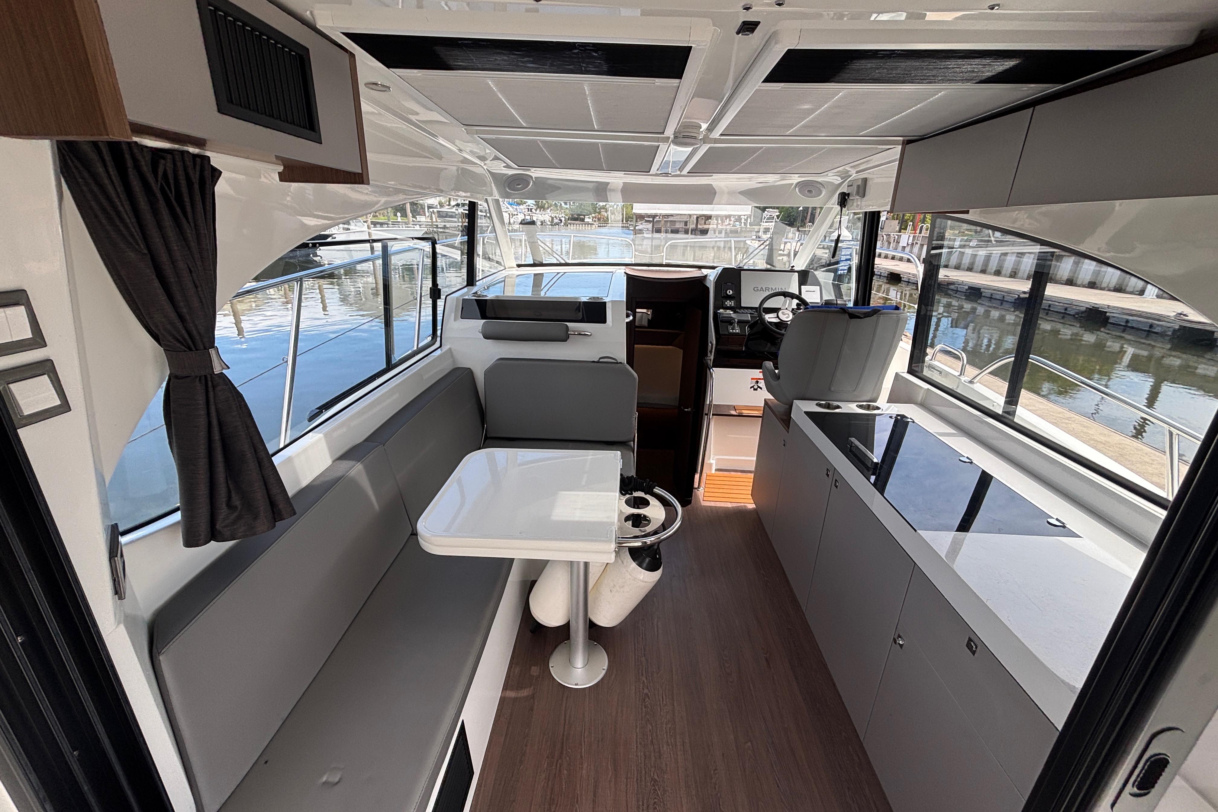 Interior of 2024 Beneteau Antares 11 yacht, featuring modern seating and helm station.