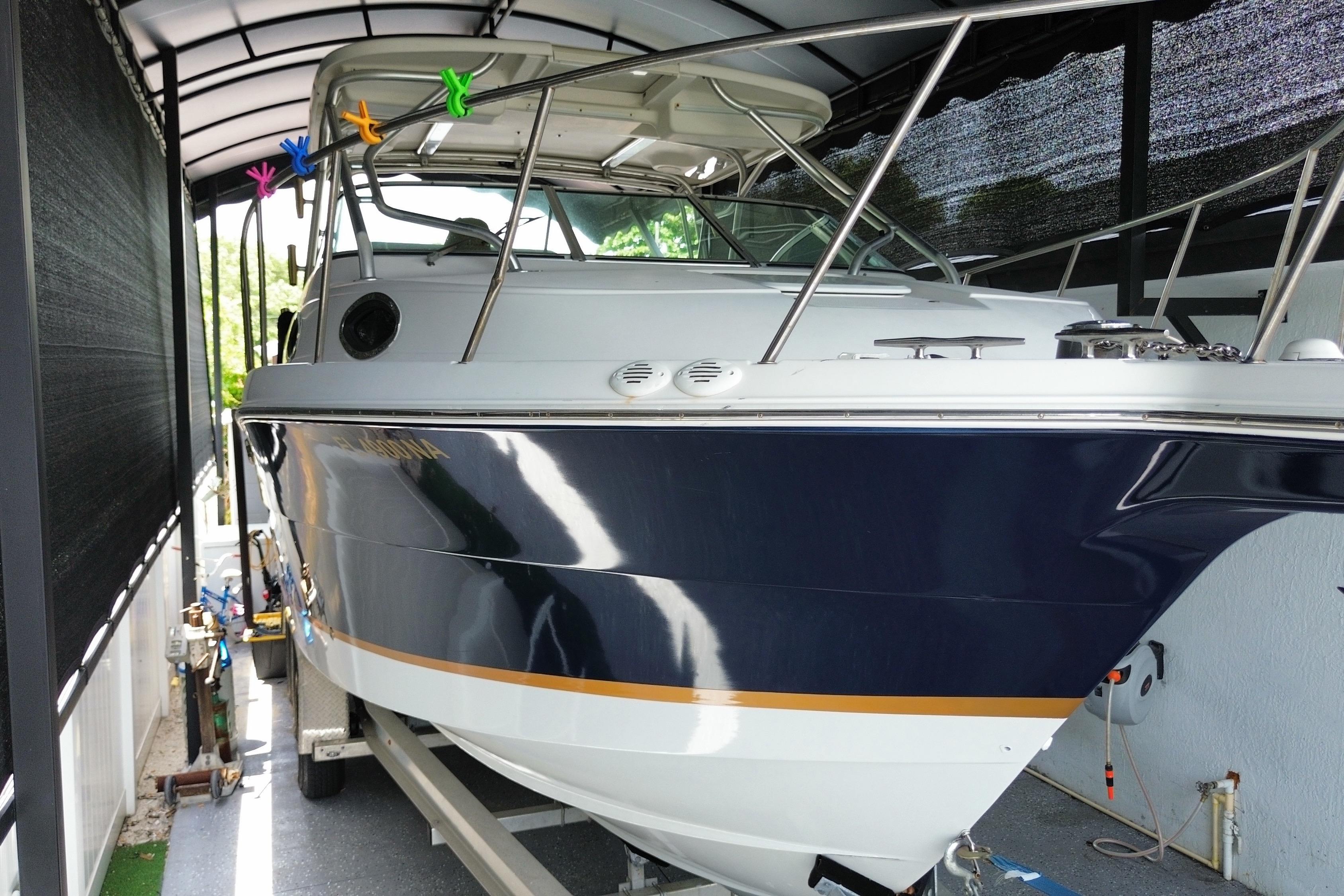 2005 Wellcraft 290 Coastal boat in covered storage, showcasing sleek design and vibrant colors.