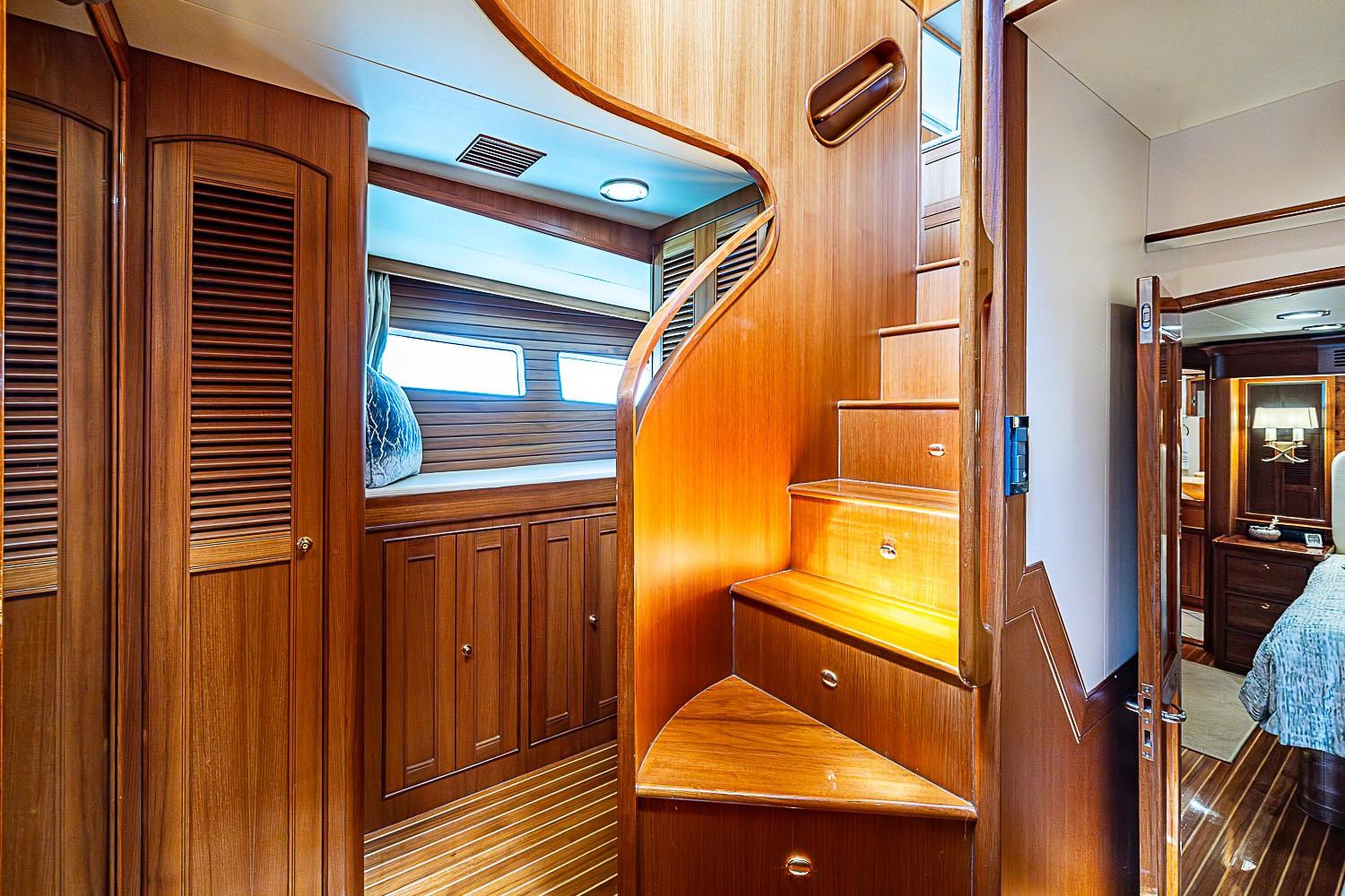 Luxurious wooden interior of 2014 Marlow 80 Explorer yacht with elegant spiral staircase.