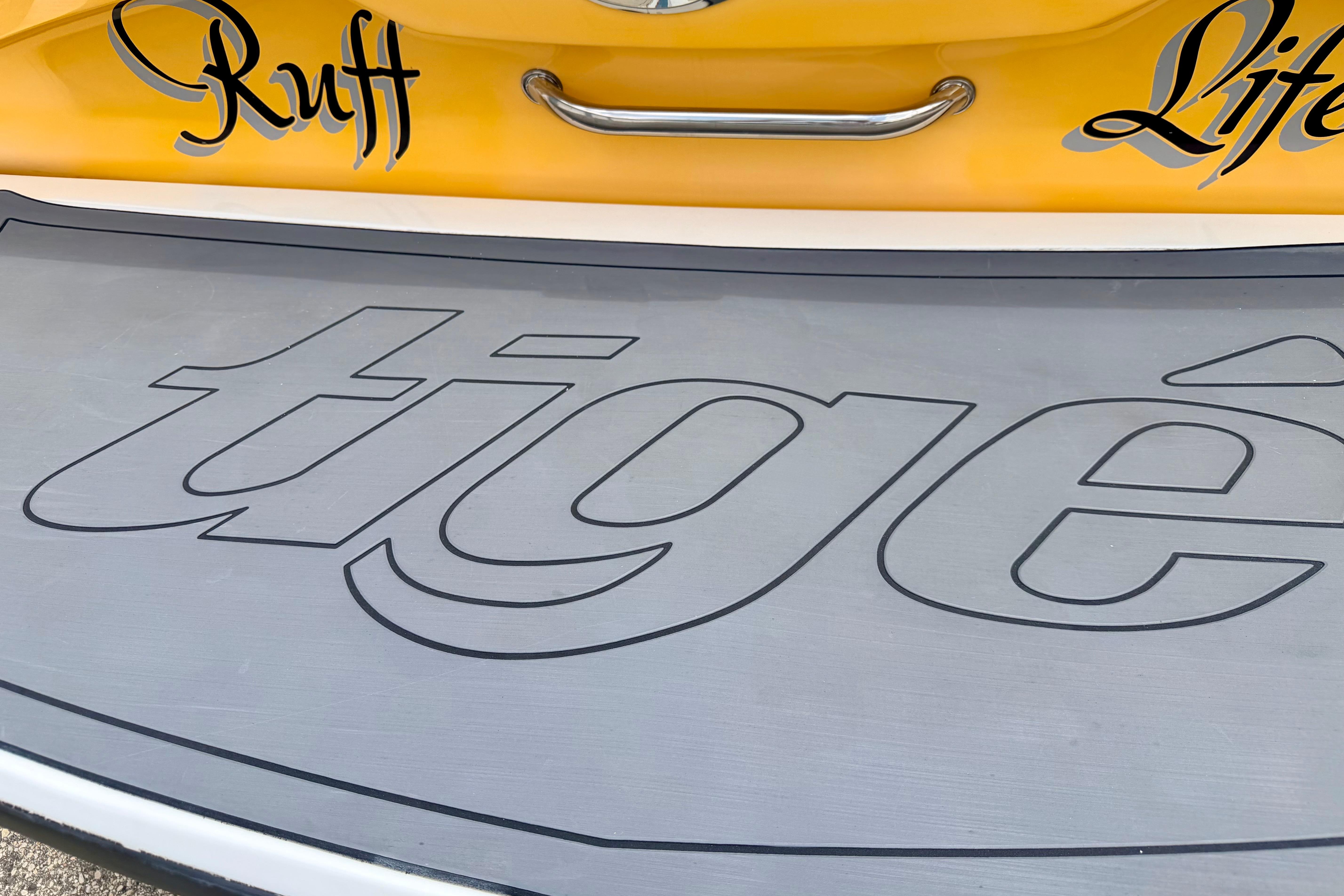 2014 Tigé R20 boat with "Ruff Life" and logo on yellow and gray surface.