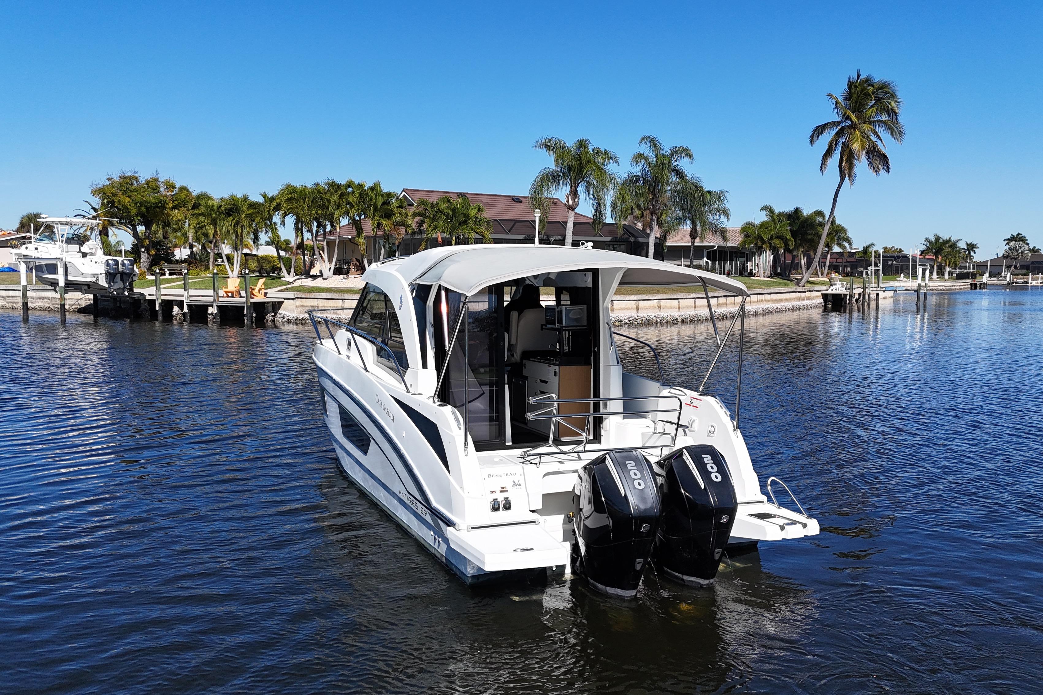 2019 Beneteau Antares 27 boat on calm water with palm trees in the background.