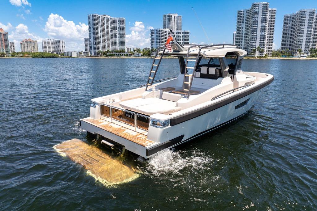2021 Bluegame BG 42 yacht cruising near city skyline on a sunny day.