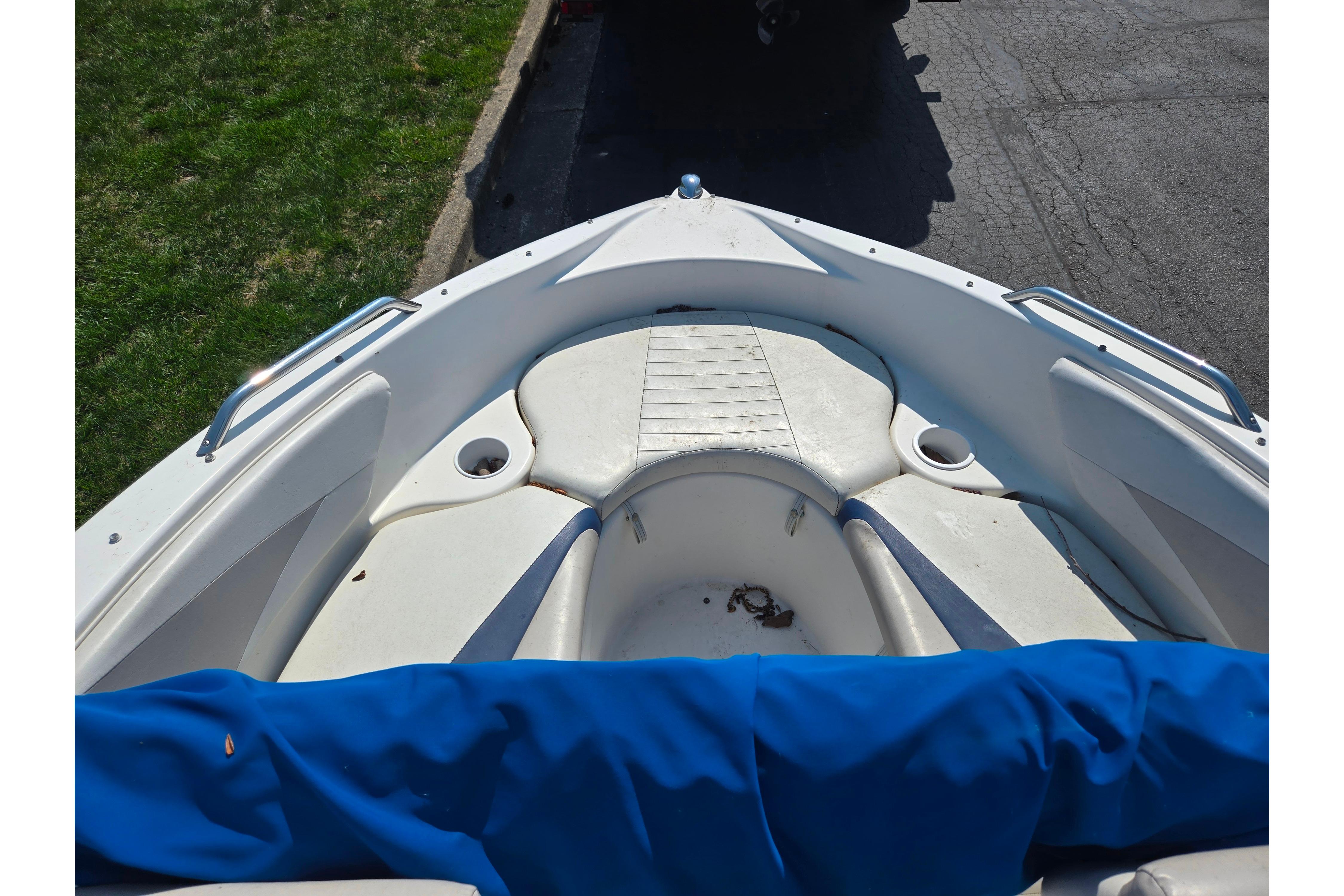 2007 Glastron GT 185 boat interior with white seating and blue cover.