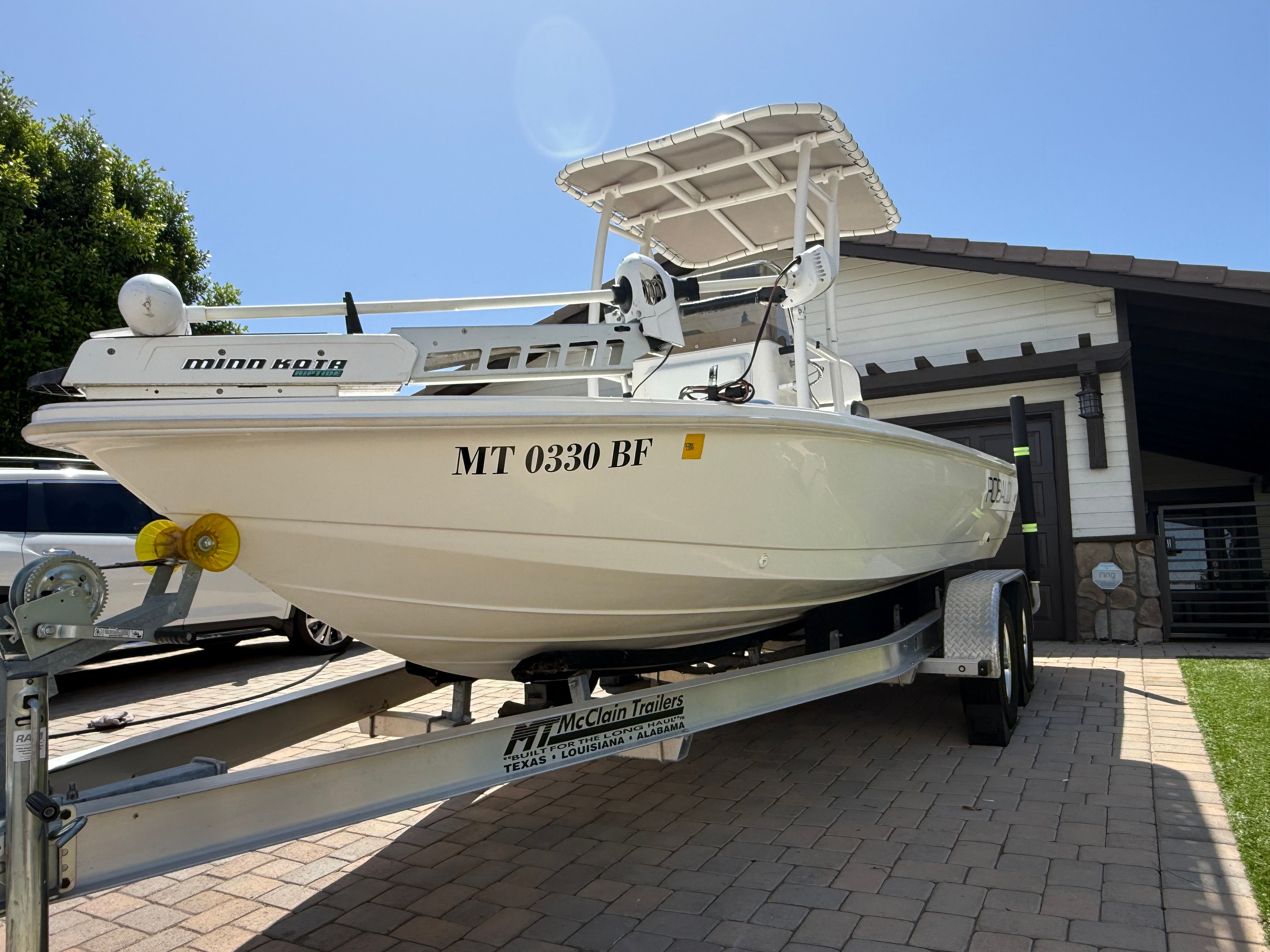 1998 Robalo 2100 Bay Hunter boat on trailer in driveway.