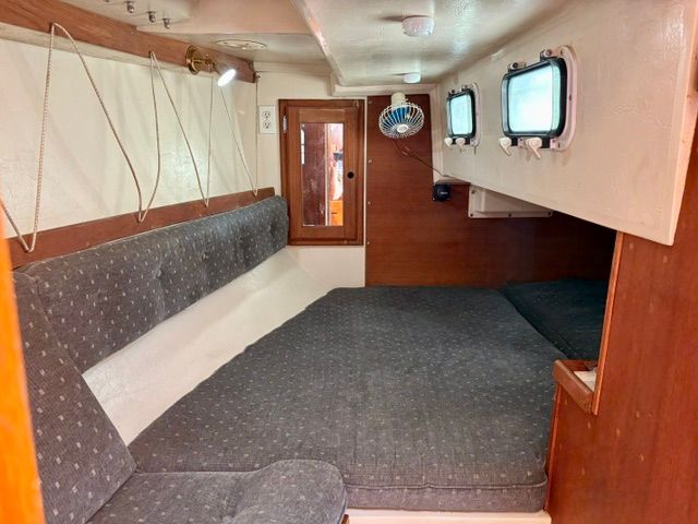 Interior of a 1989 Catalina 34 with cushioned seating and portholes.