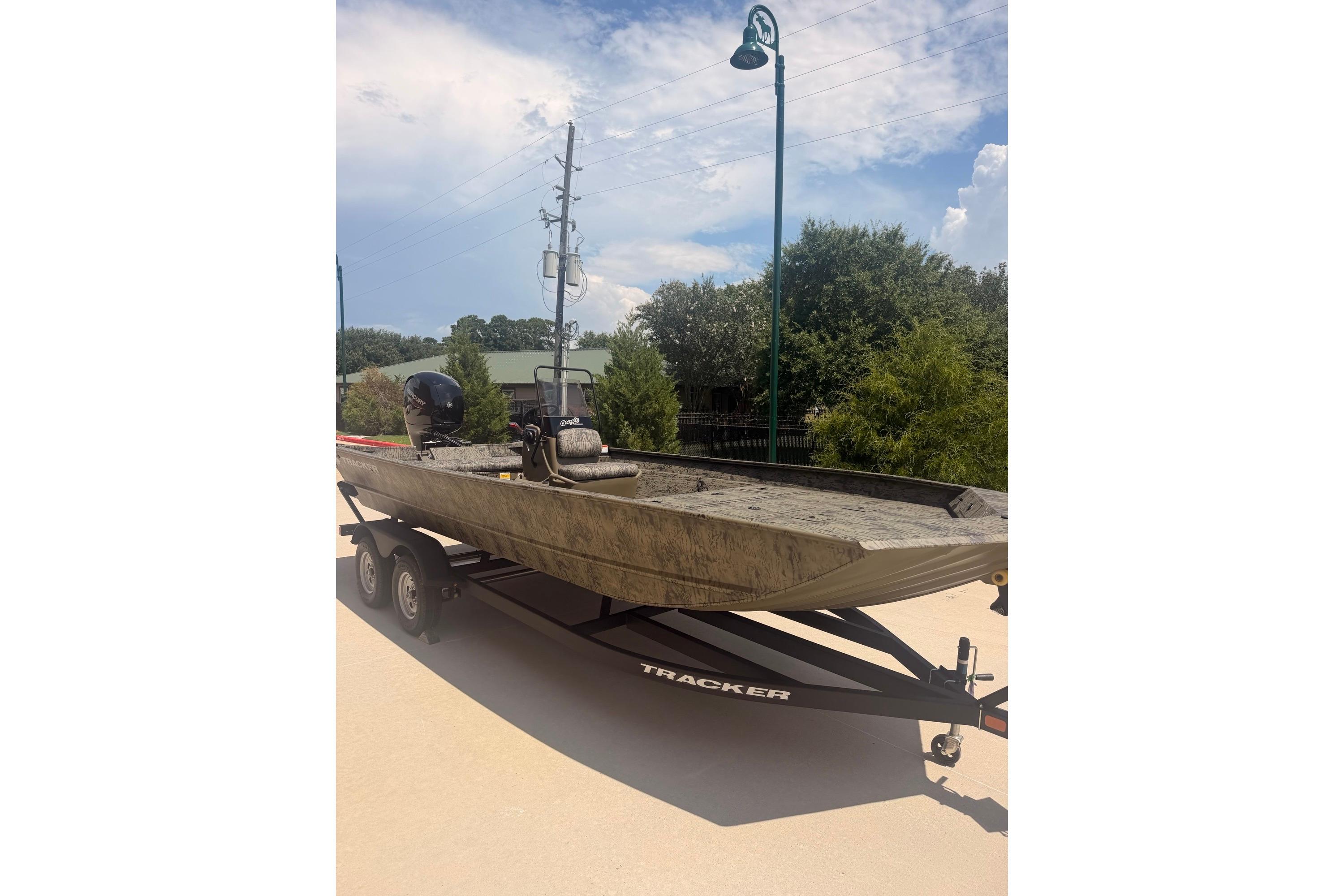 2026 Tracker Grizzly 2072 CC boat on trailer, outdoors under a clear sky.