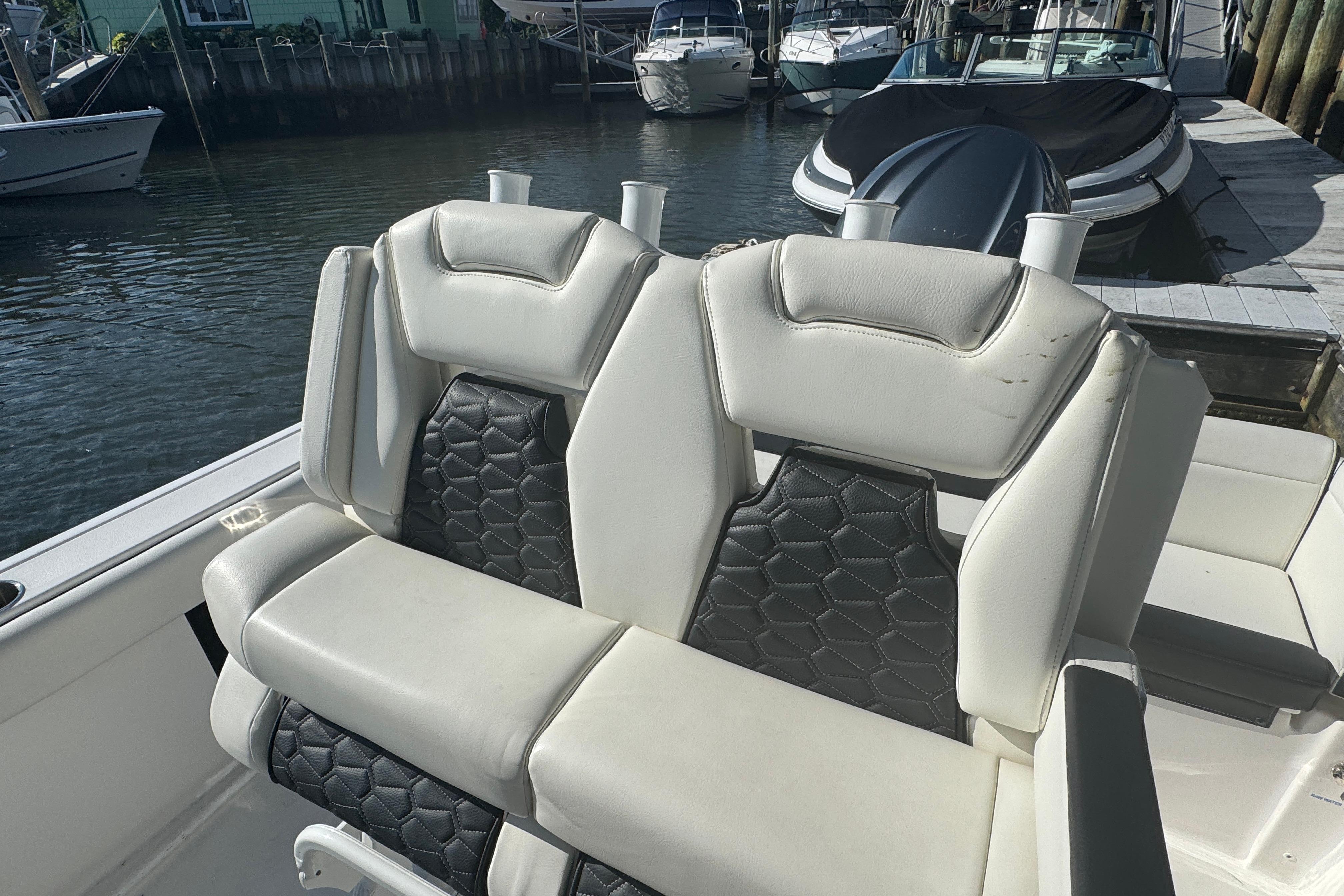 2025 Tidewater 232 LXF boat seats with black and white upholstery at a marina.