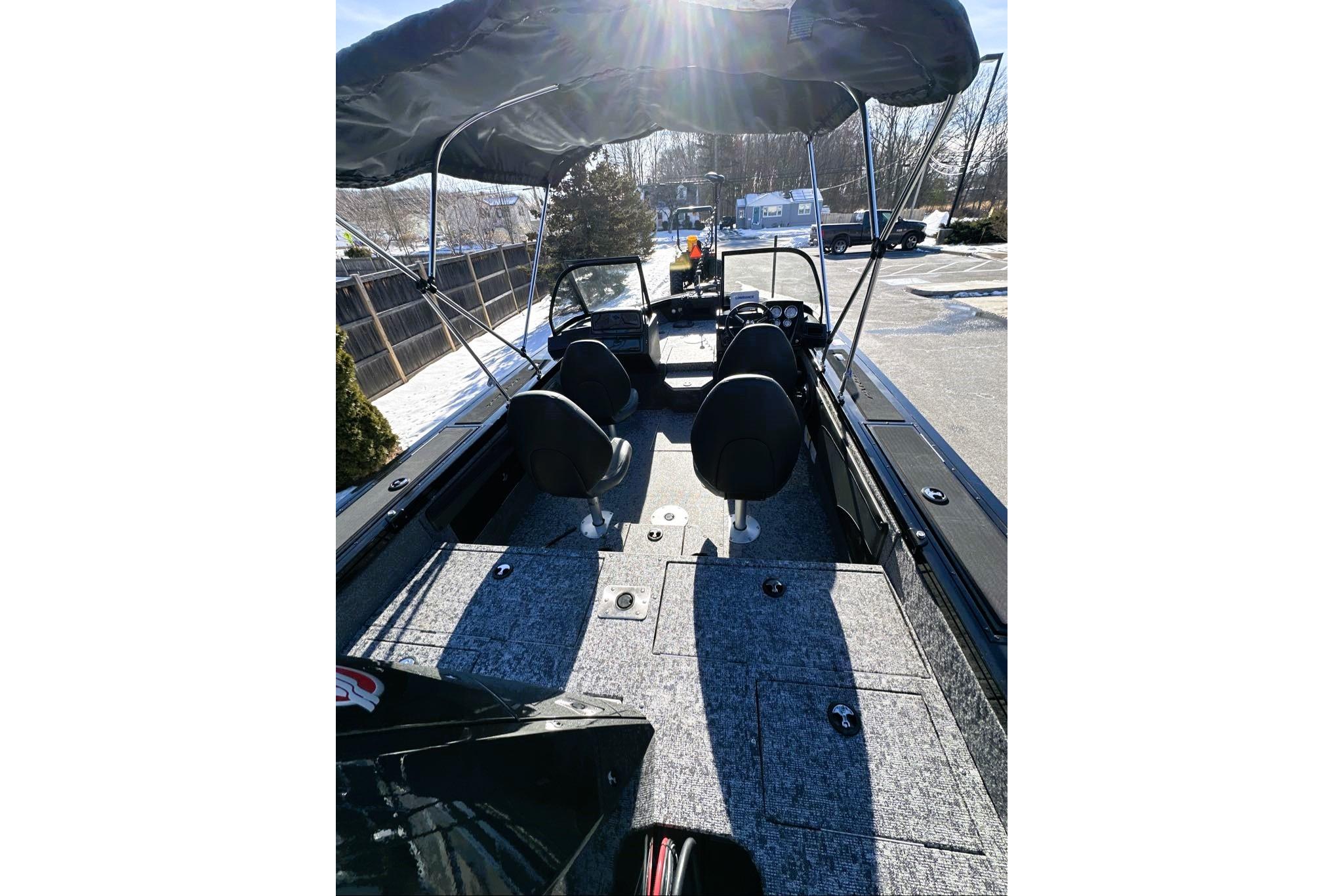 2026 Tracker Targa V-19 WT boat interior with canopy, seats, and dashboard in sunlight.