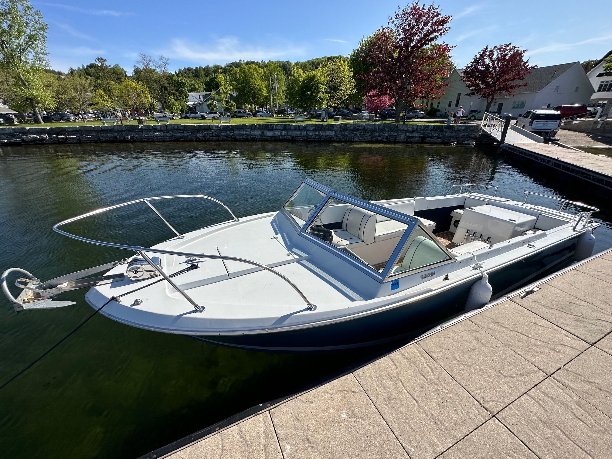 A 1969 John Allmand Citation II boat docked. It features an open cabin and sleek lines.