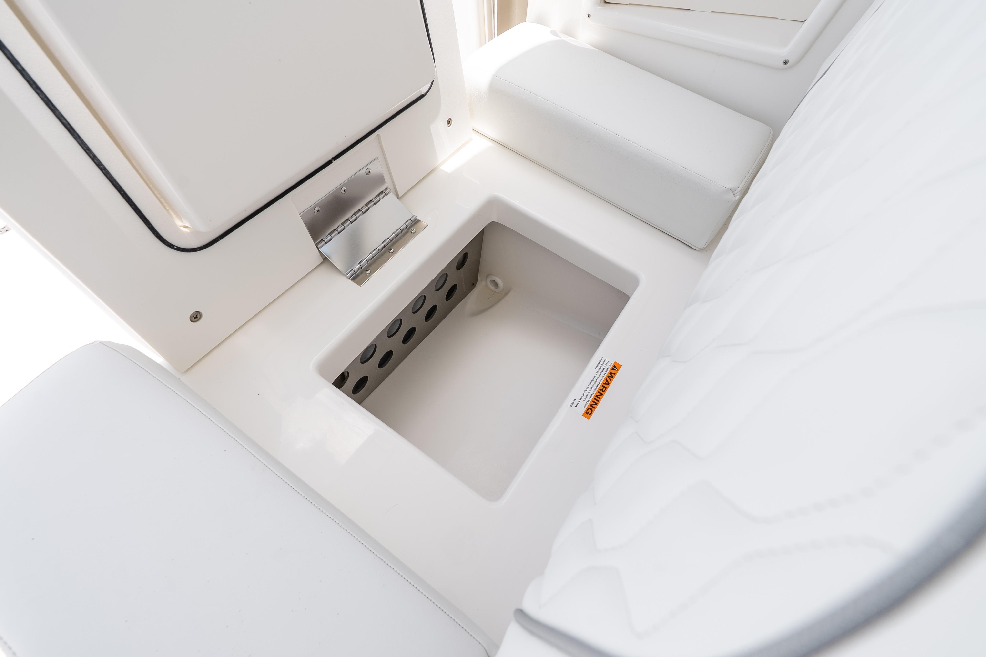 2026 Pursuit DC 326 Dual Console storage compartment with cushioned seating and stainless steel hinge.