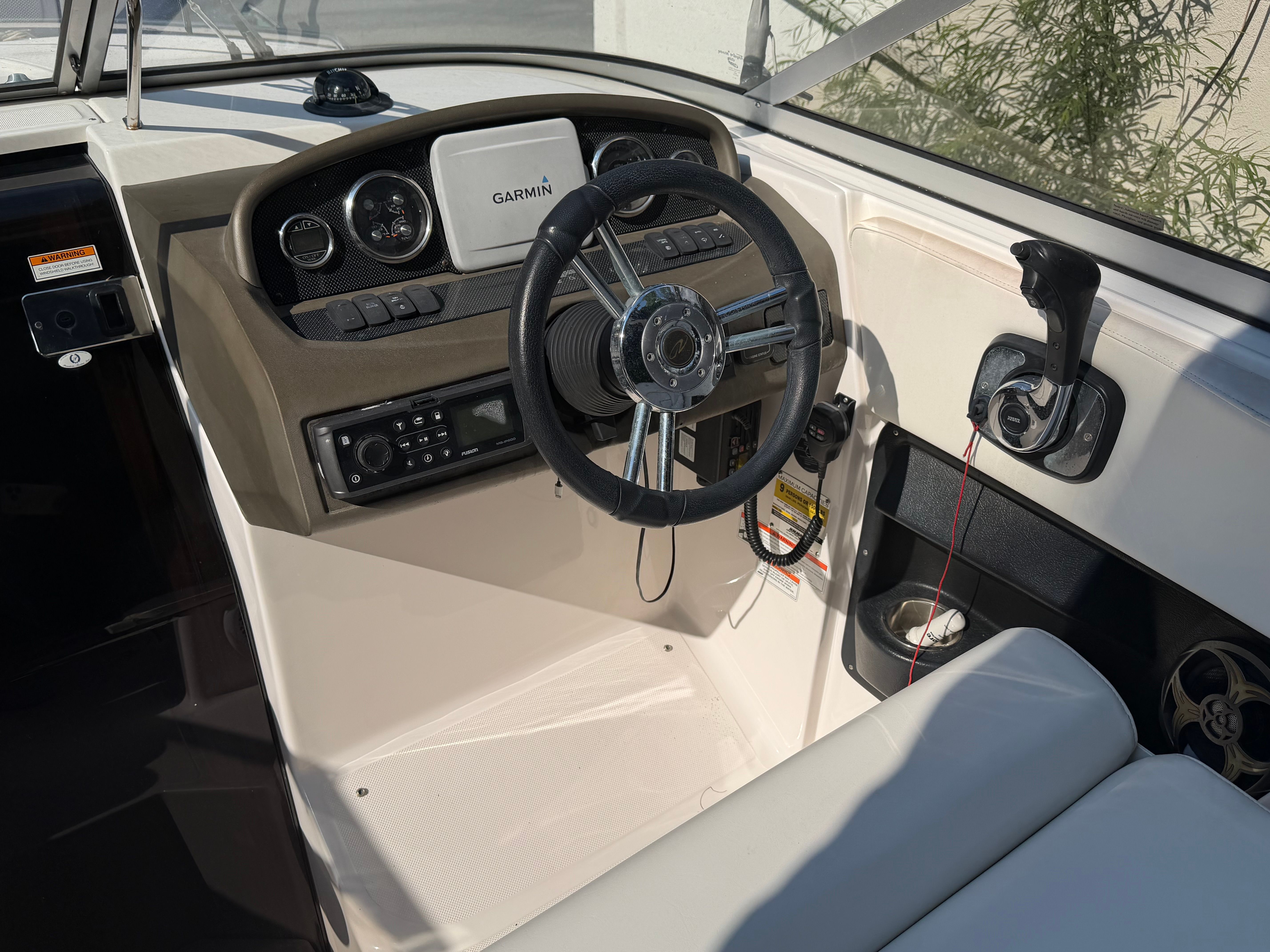 The cockpit of a 2011 Regal 2750 Cuddy featuring a Garmin navigation system and steering wheel.