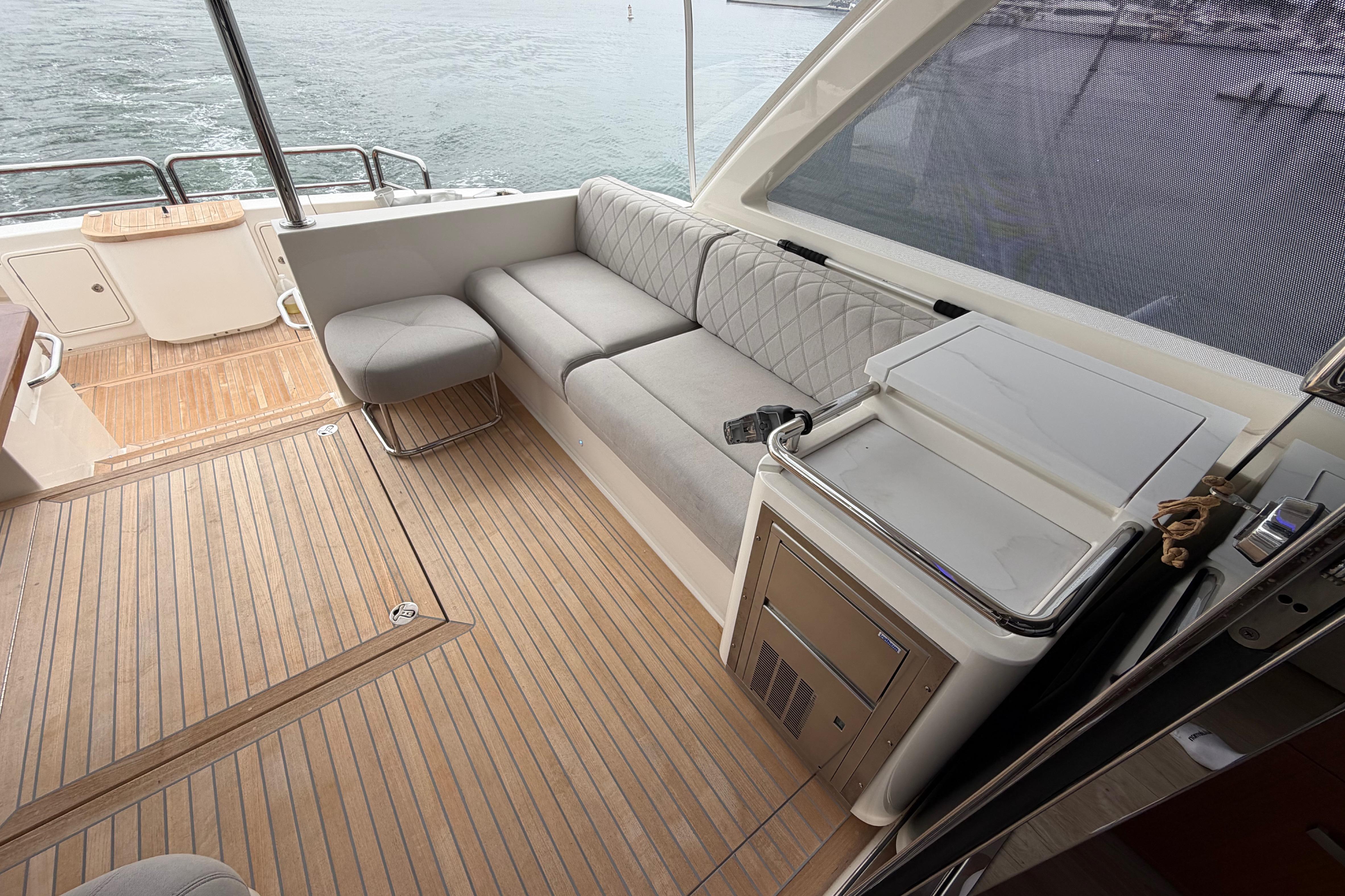Luxurious interior of 2023 Riviera 645 SUV yacht with elegant seating and wooden flooring.