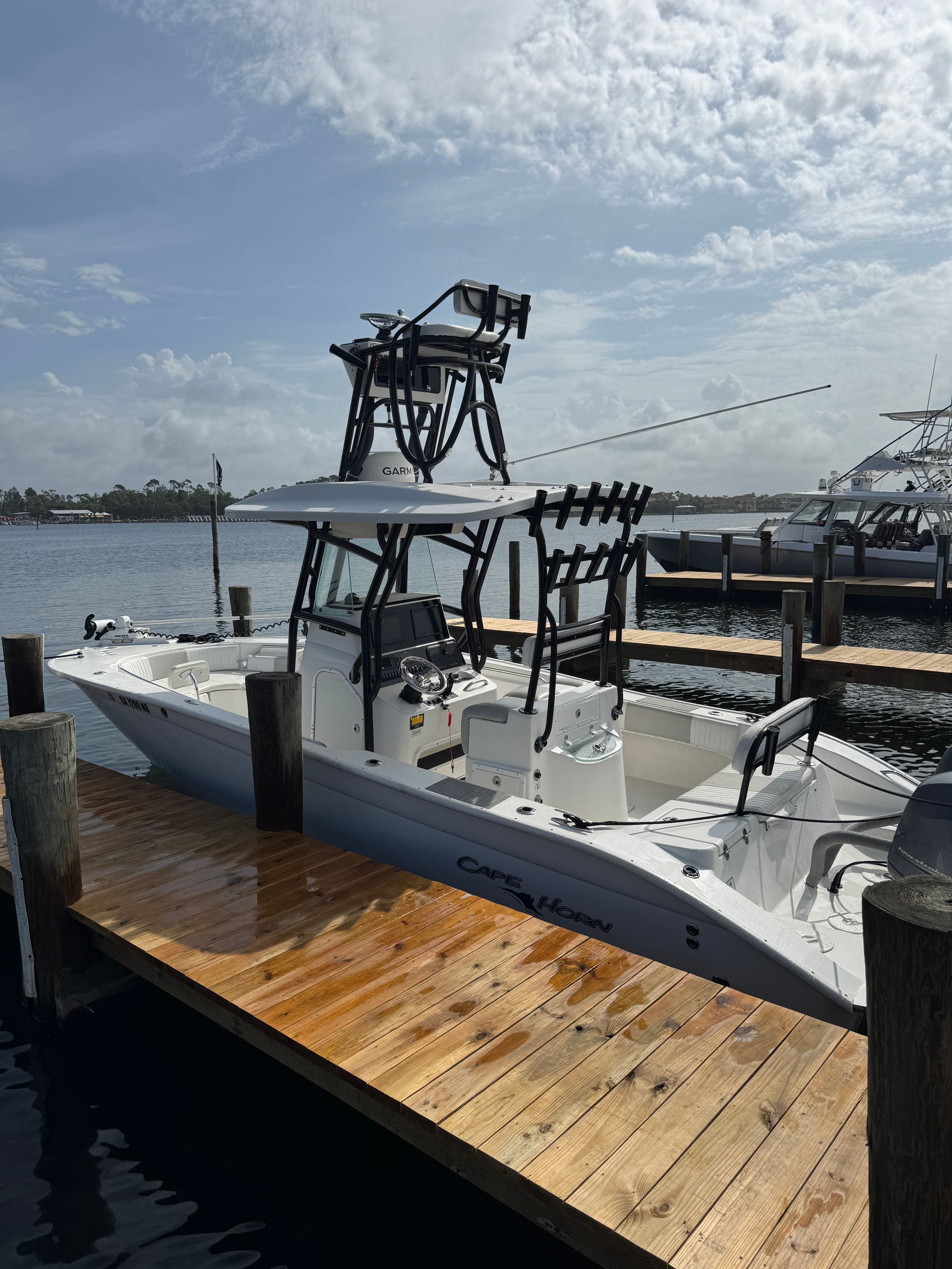 A 2014 Cape Horn 24XS boat docked at a wooden pier. It features an elevated helm.