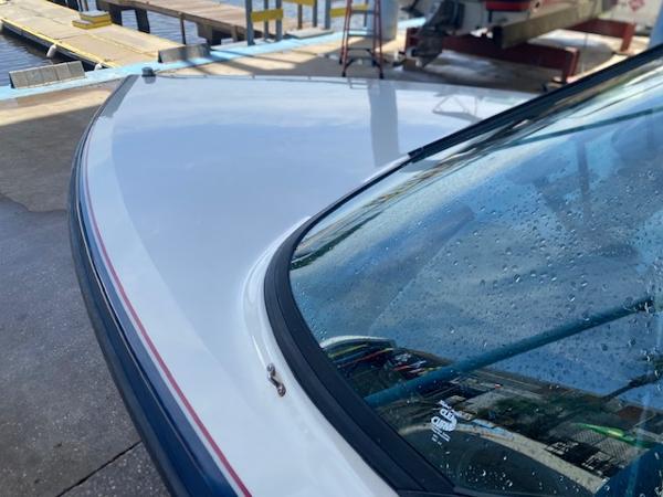 1998 Malibu Response boat with water droplets on windshield, dockside view.