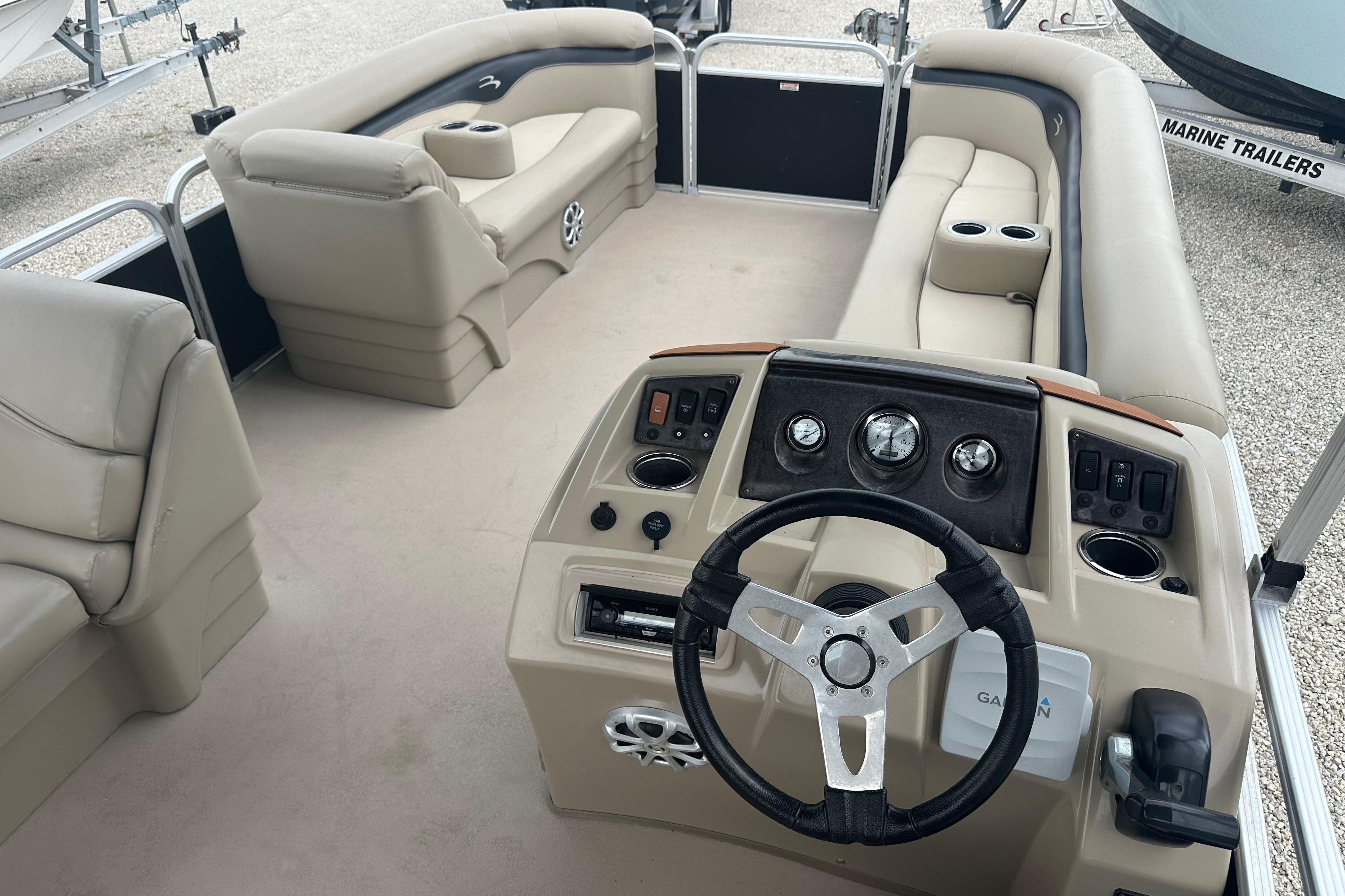 2014 Bennington S22 pontoon boat interior with beige seating and steering console.