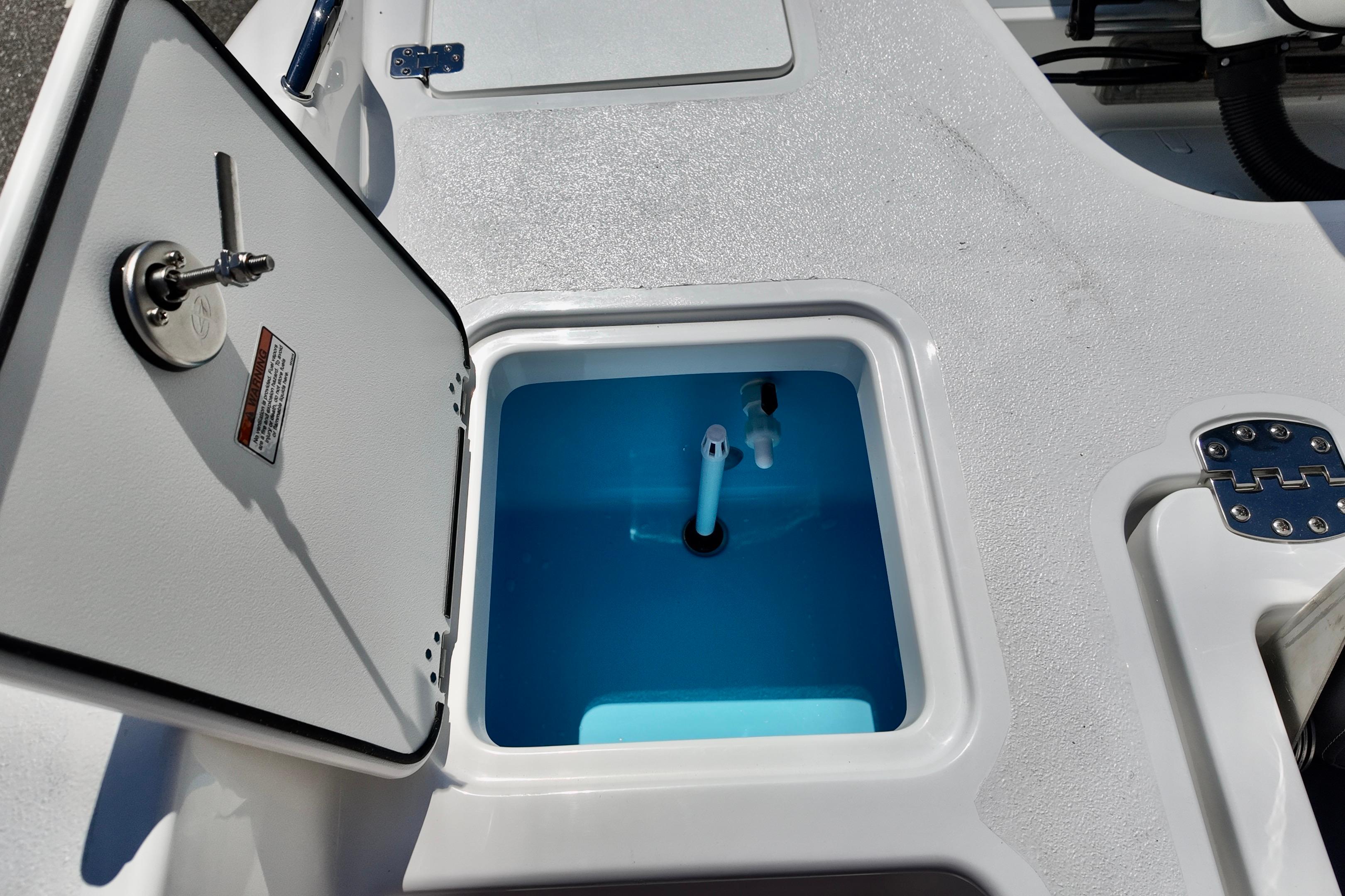Open storage compartment on 2026 NauticStar 251 Hybrid boat, featuring a blue interior.