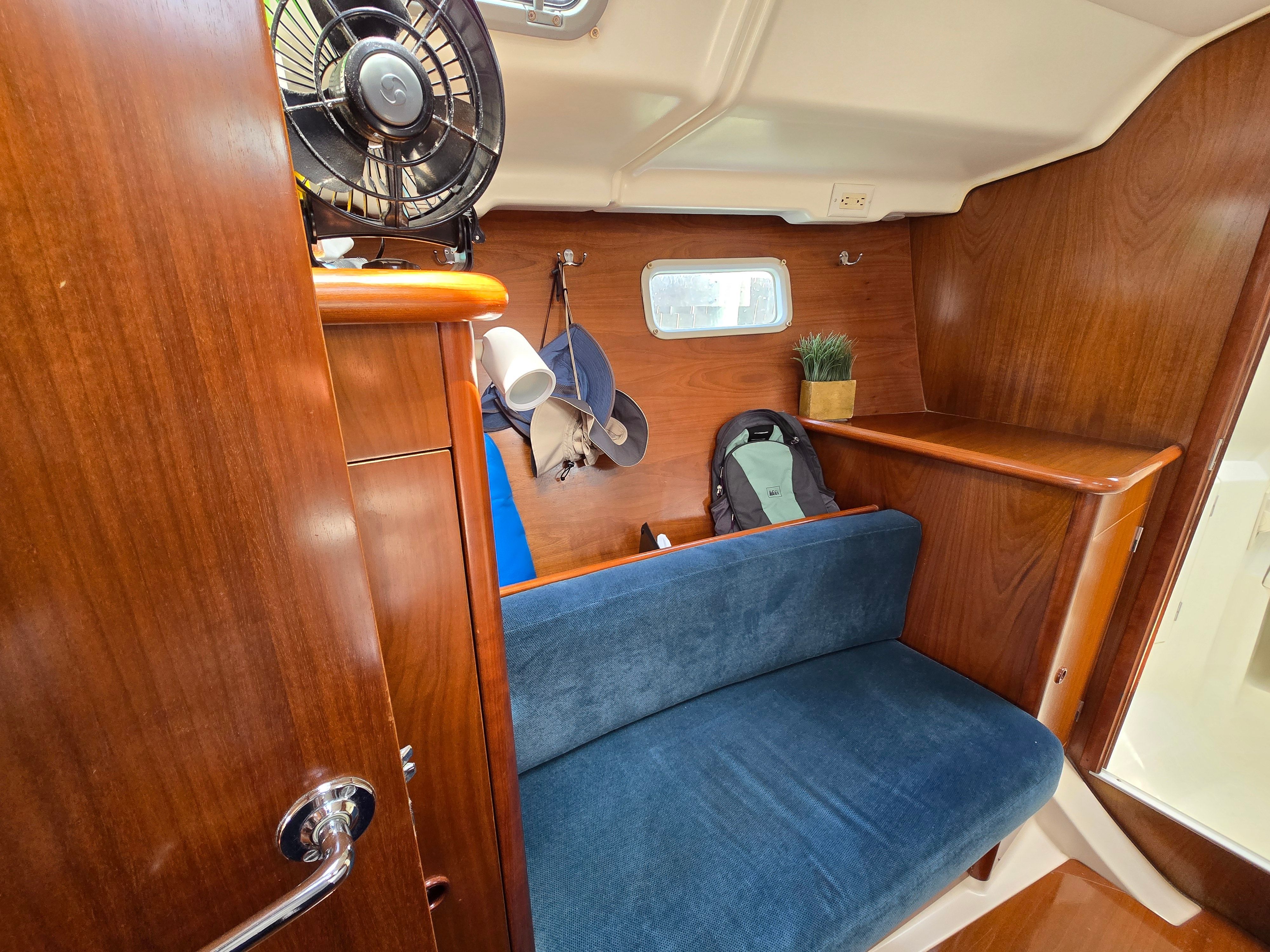 Interior of a 1998 Beneteau 411 with blue seating and wooden walls.
