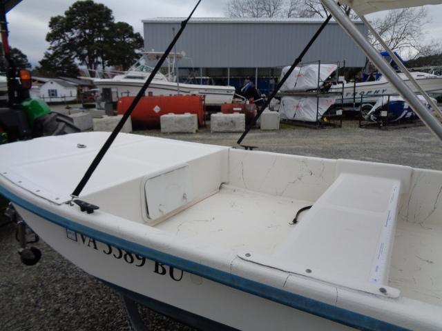 2010 Sundance K14T boat in a marina, white hull, open deck, parked outdoors.