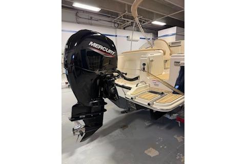 2021 Scout 215 Dorado boat with Mercury outboard motor in a garage.