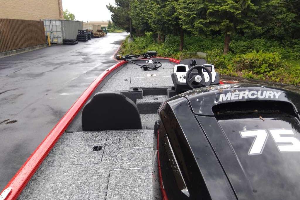2026 Tracker Pro Team 175 boat with Mercury engine, parked on a wet road.