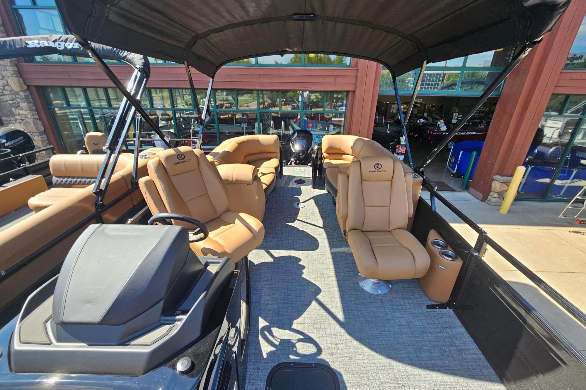 2026 Regency 230 DL pontoon boat with tan seating and black canopy.