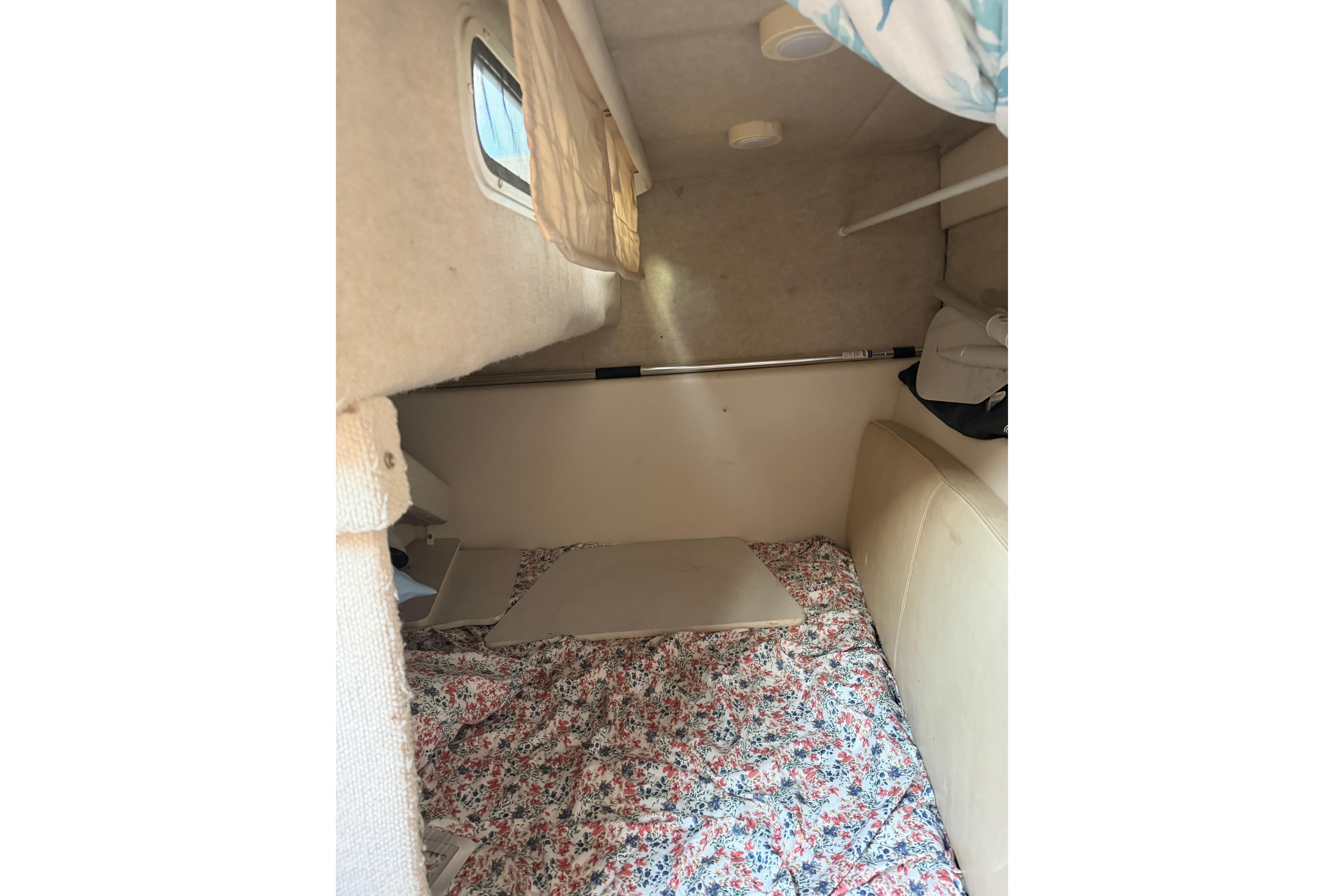 Interior cabin of 2001 Maxum 2800 SCR boat with floral bedding.