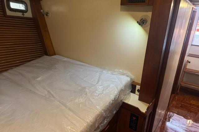 Cozy cabin interior of 1986 Kadey-Krogen 42 yacht with bed and wooden accents.