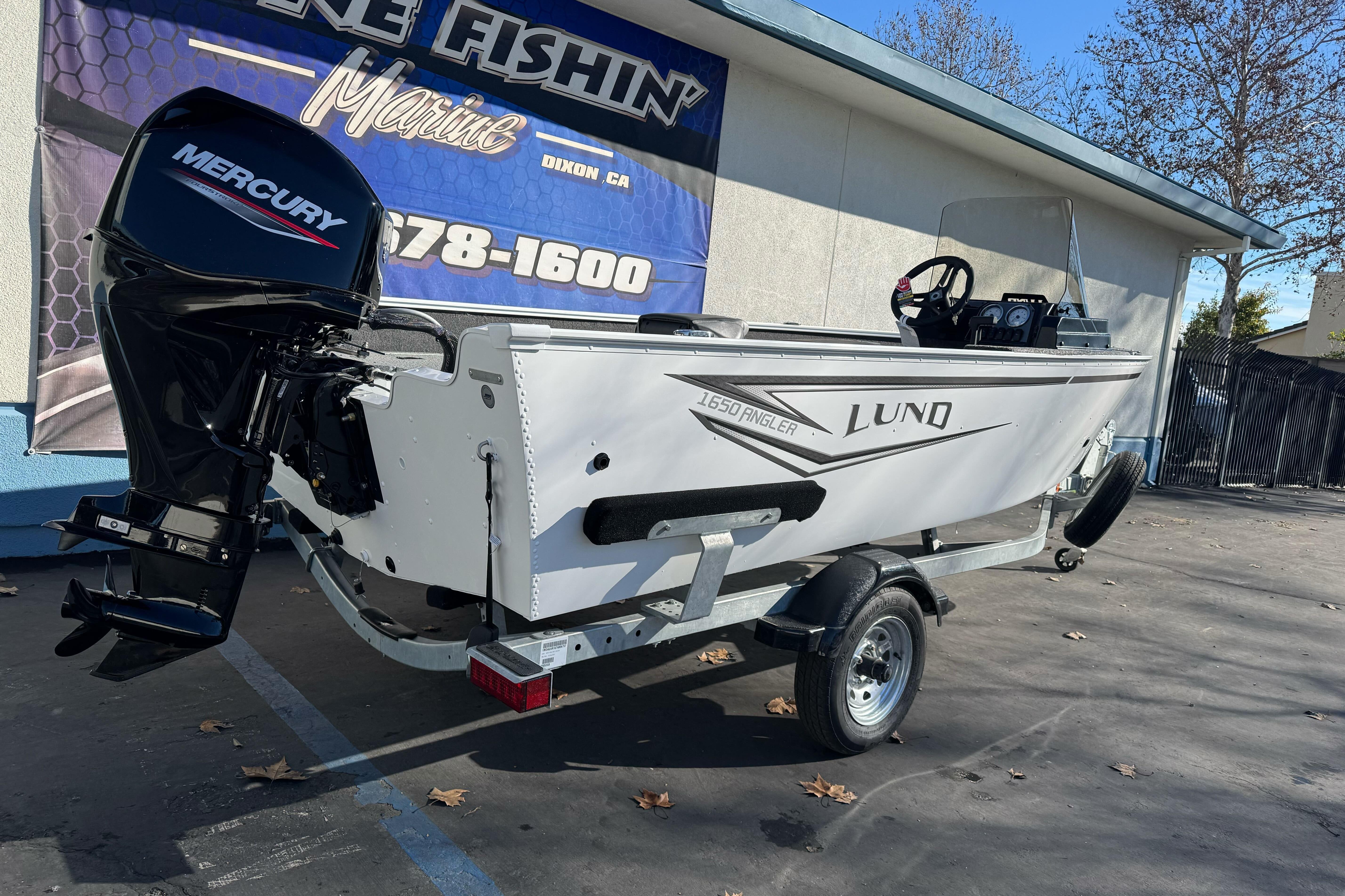 2026 Lund 1650 Angler SS boat with Mercury engine on trailer, outdoor display.