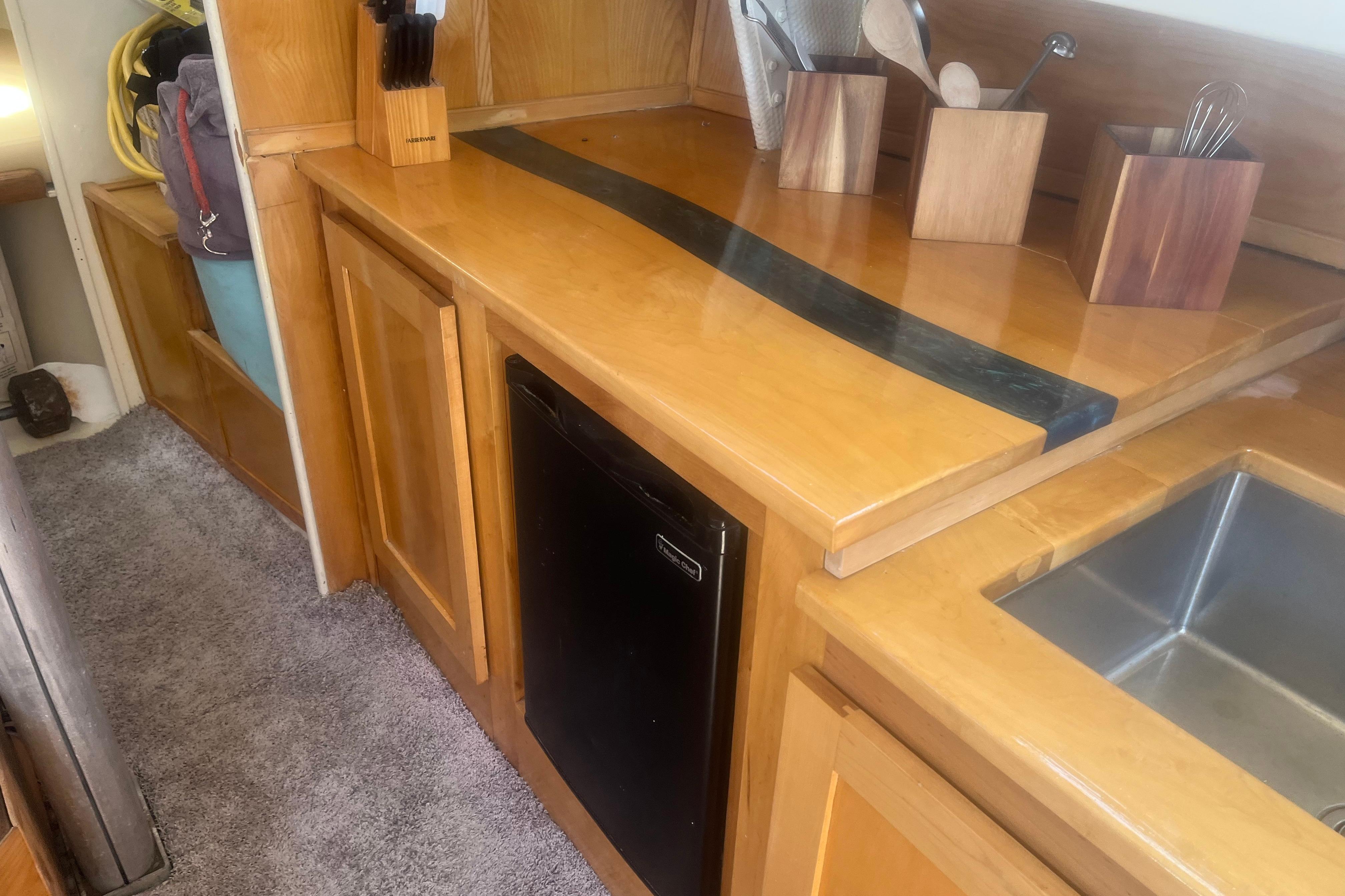 Wooden kitchen interior of a 1972 C&C 30 sailboat with countertop and sink.