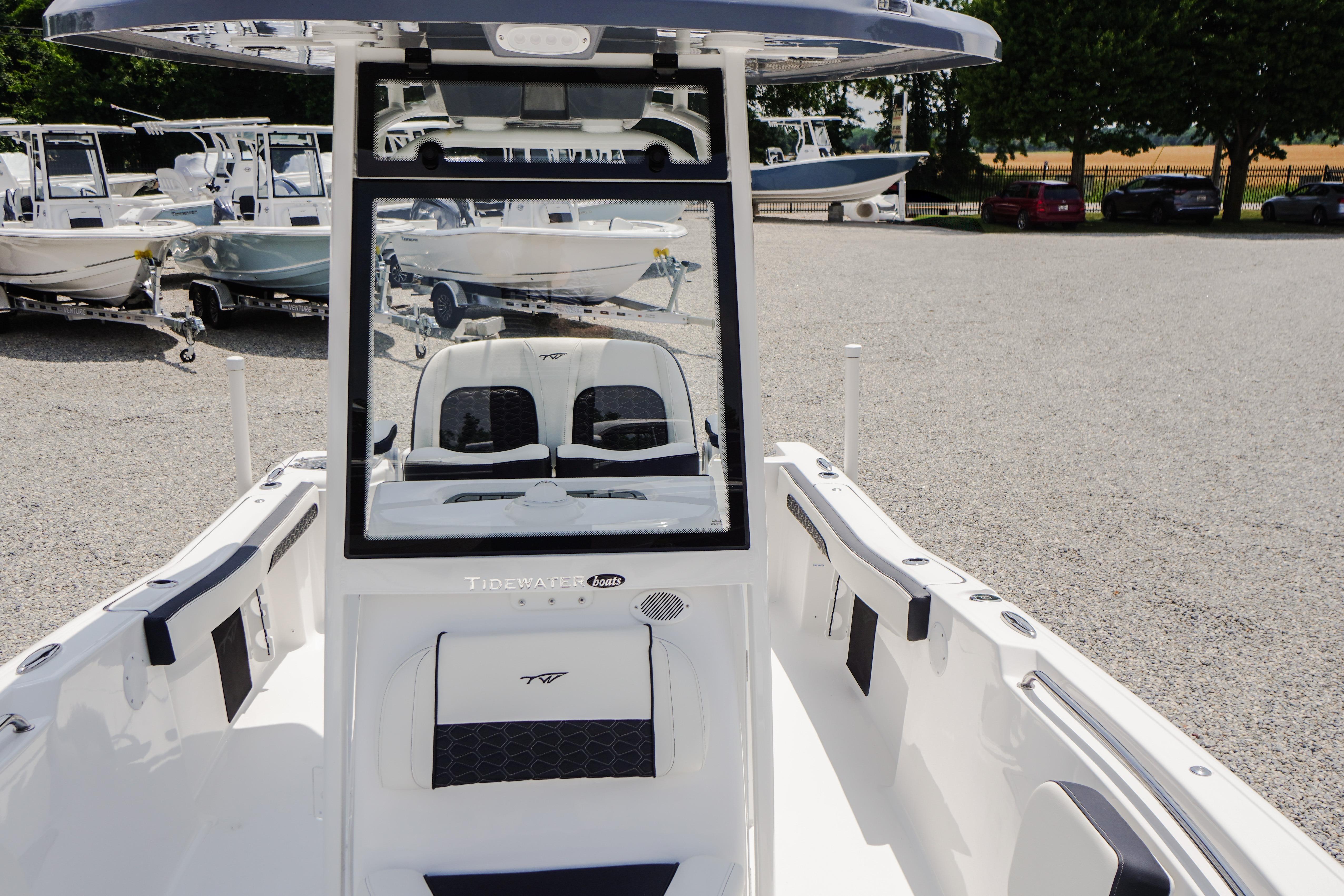 2027 Tidewater 220 CC Adventure boat interior with seating and console, parked outdoors.