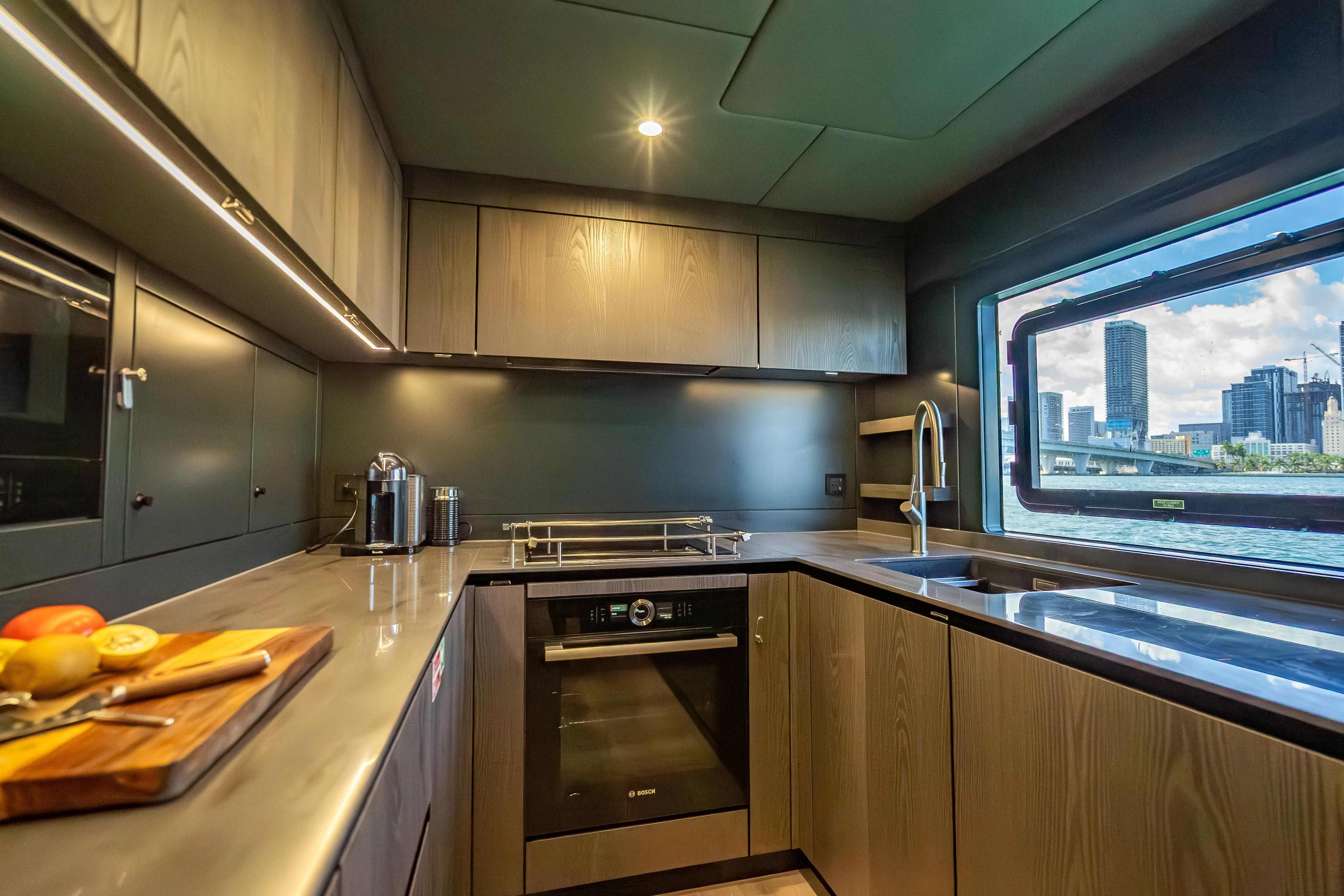 Luxurious kitchen interior of 2026 Sunreef 60 Power yacht with cityscape view.