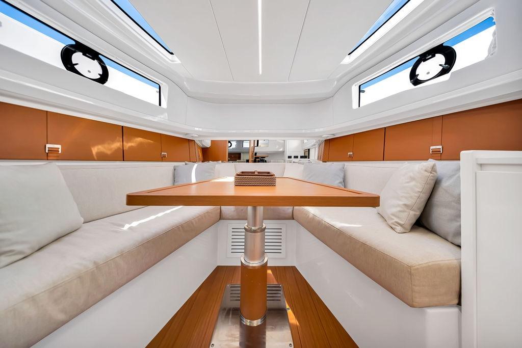 Luxurious interior of 2021 Bluegame BG 42 yacht with elegant seating and wooden table.