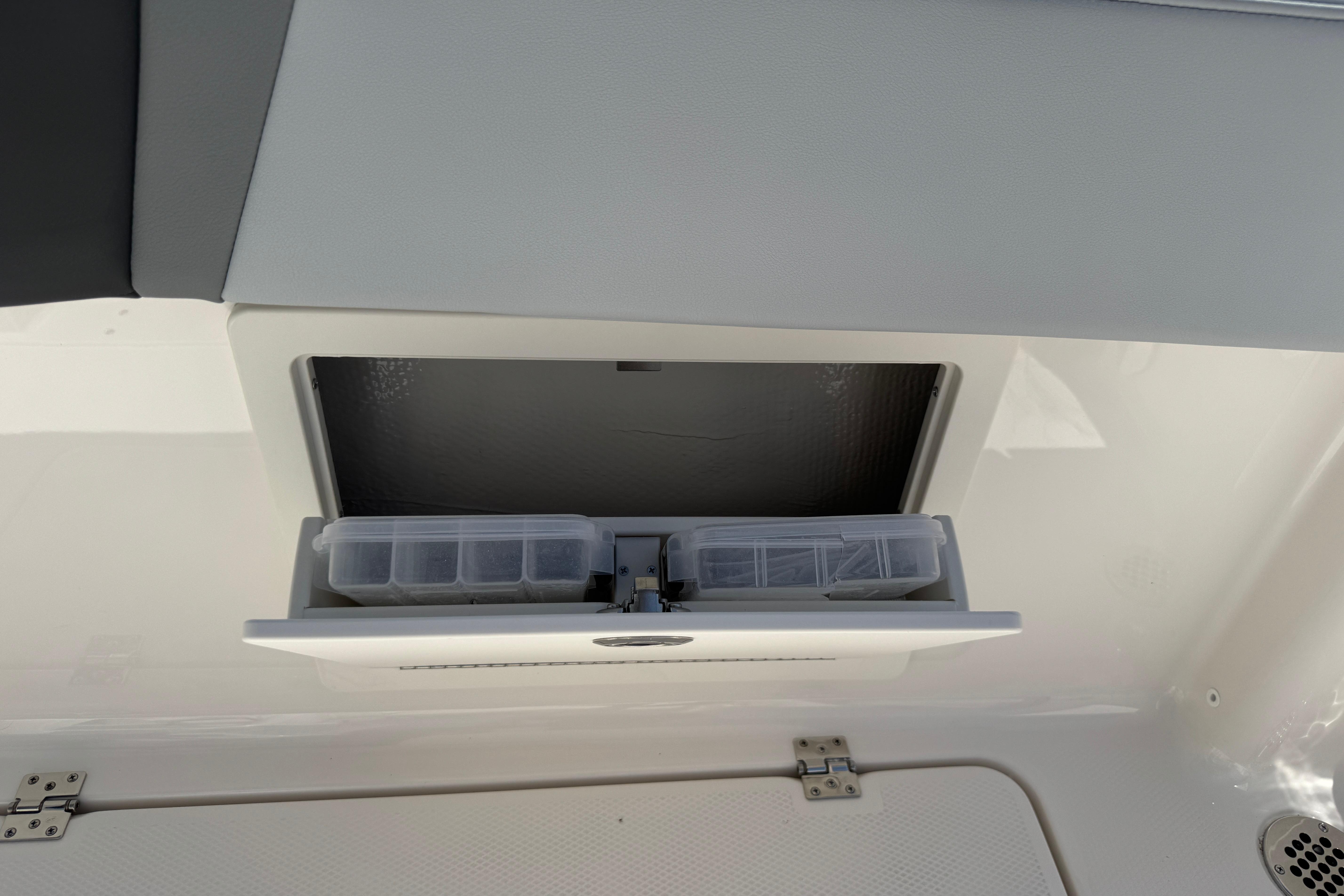 2026 Robalo R250 Center Console boat storage compartment with tackle boxes.