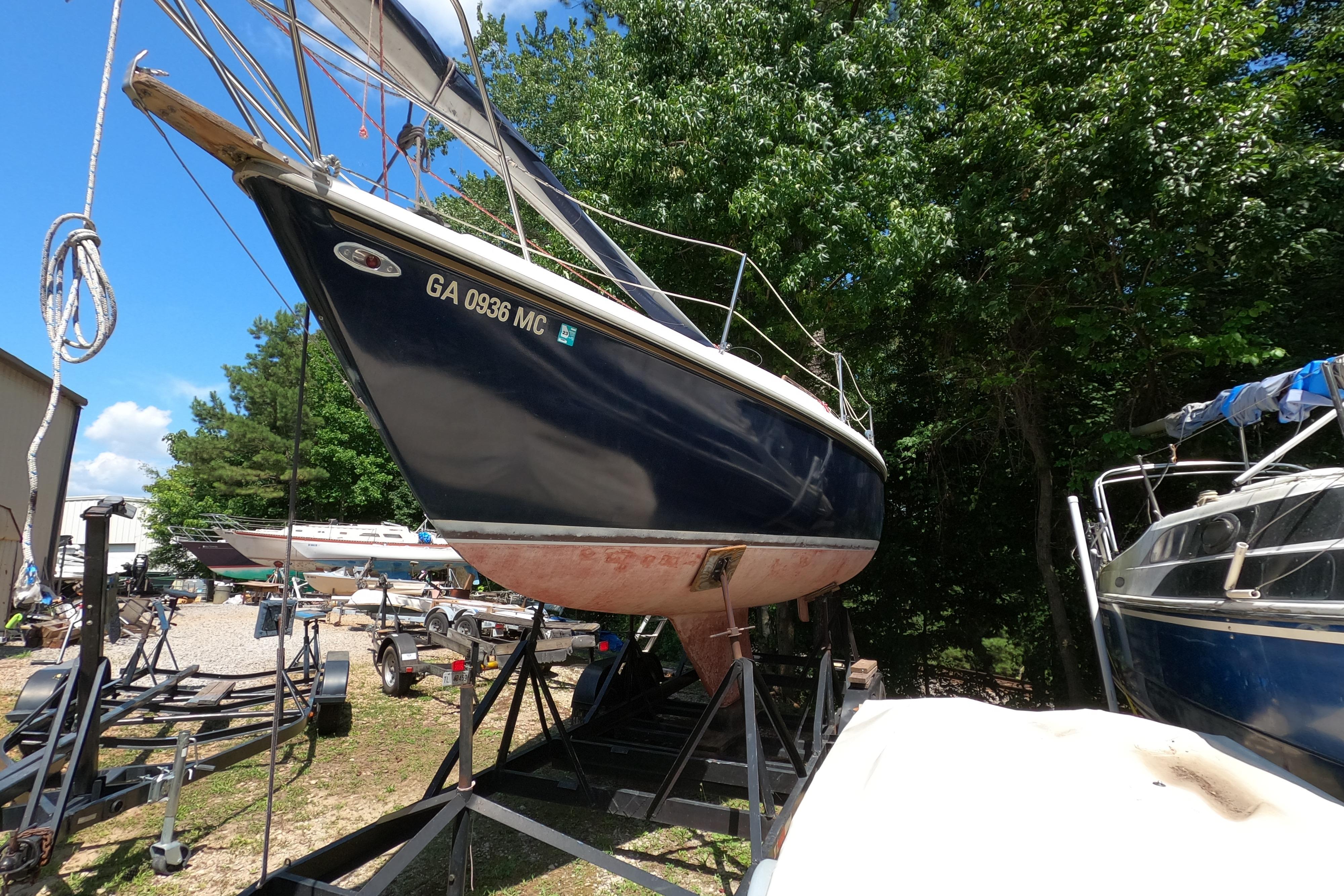 1984 Catalina 27 sailboat on trailer, surrounded by trees and other boats.