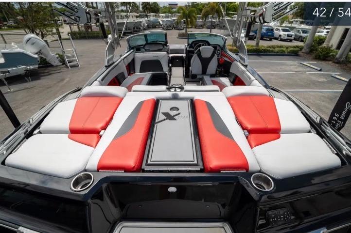 2019 MasterCraft XStar boat interior with red and white seating, parked outdoors.