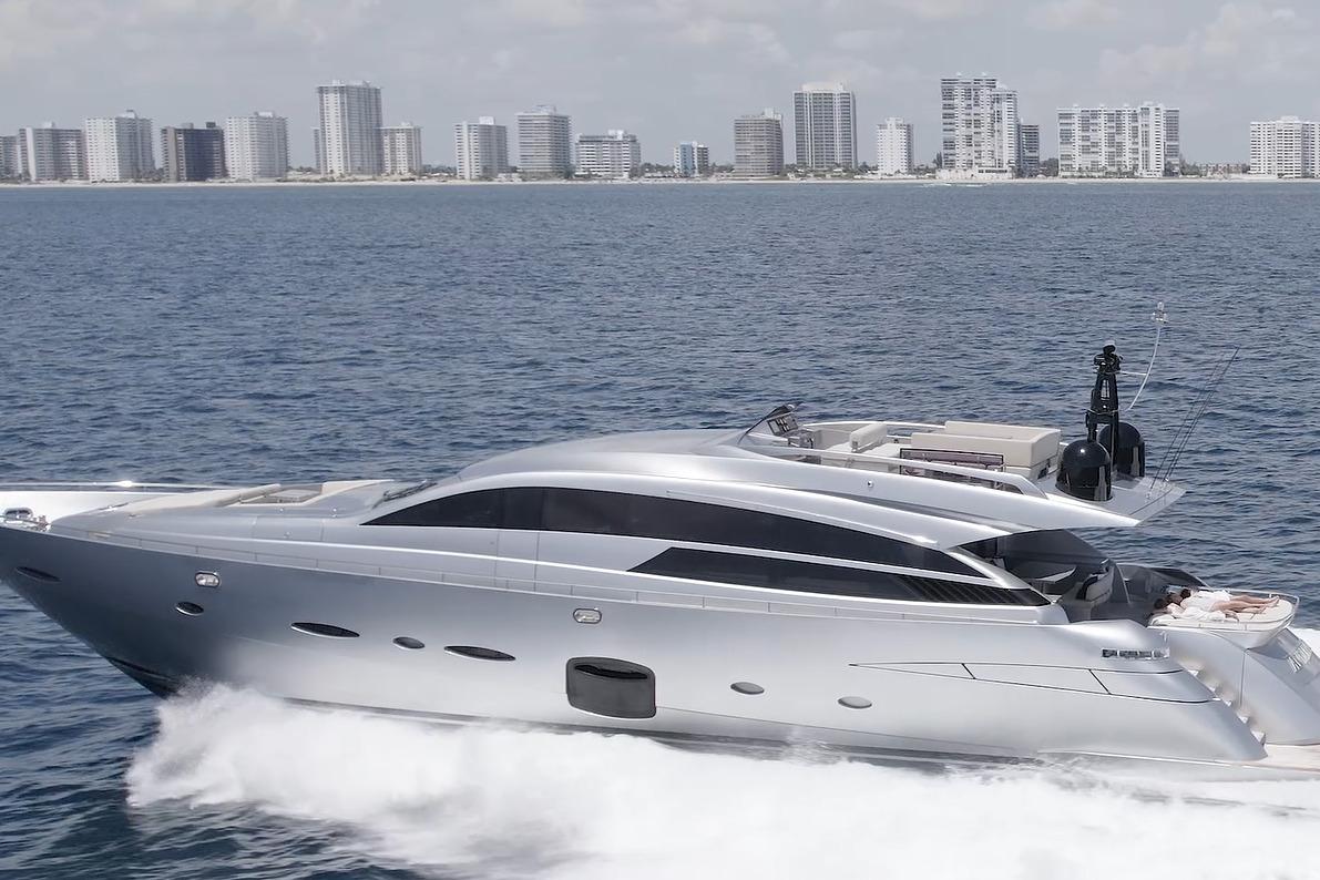 Luxury 2015 Pershing 92 yacht cruising near city skyline.